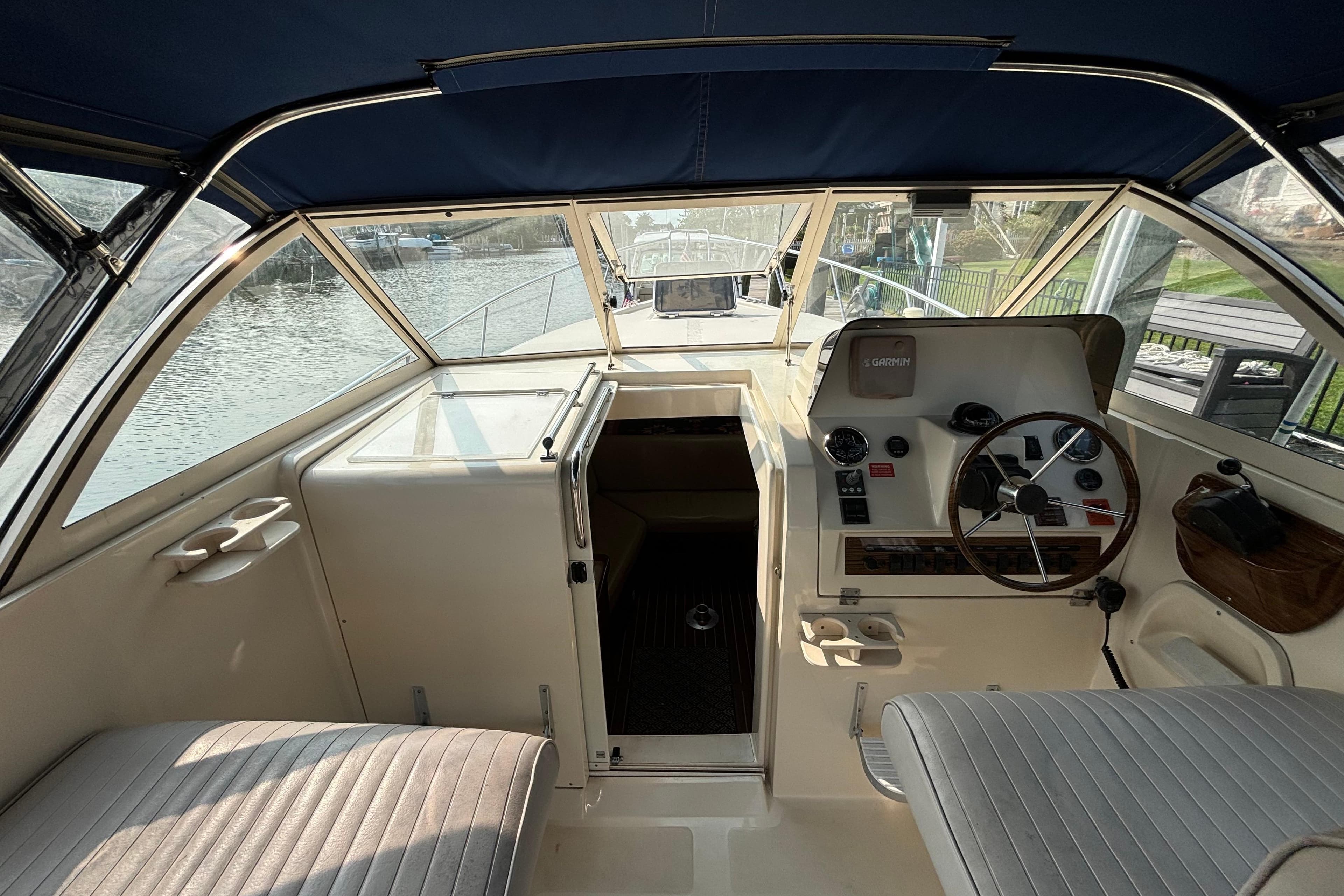 2005 Mainship Pilot 30-II Sedan interior with helm, seating, and water view.