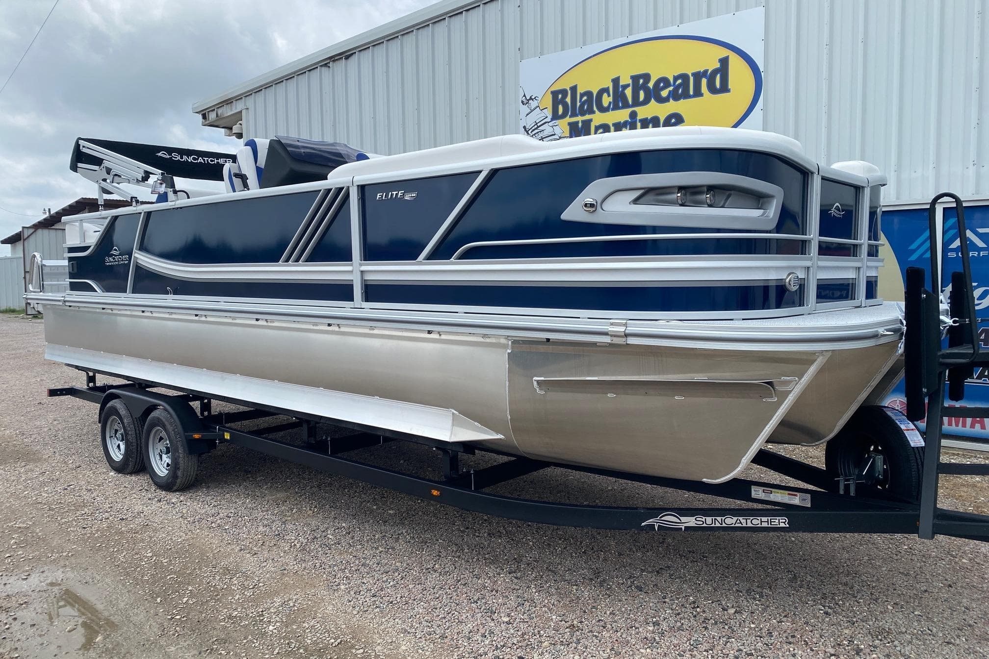 2026 SunCatcher Elite 326 SS pontoon boat on trailer at BlackBeard Marine dealership.