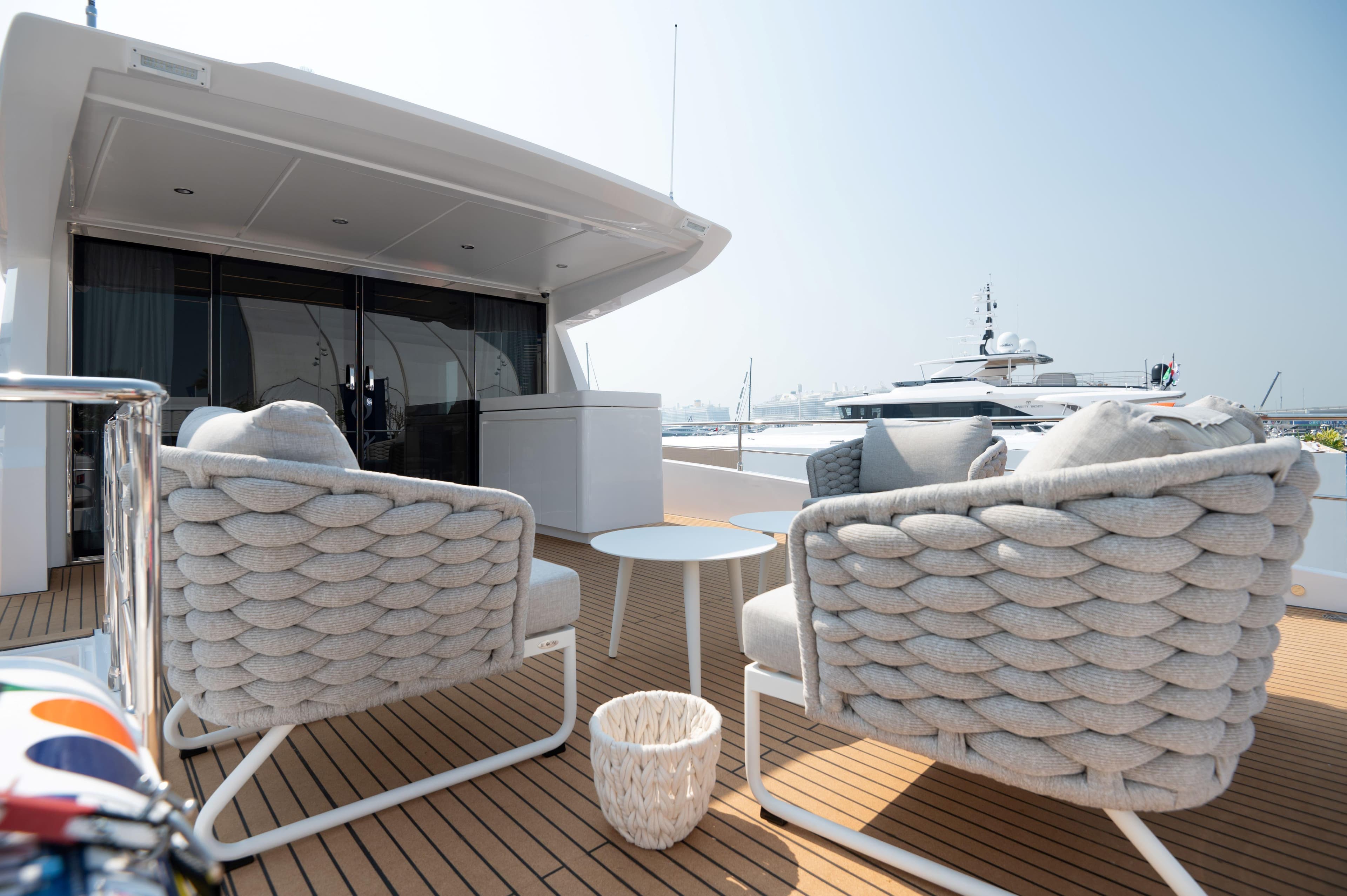 Luxury deck of 2025 Nomad 70 SUV yacht with stylish seating and table.