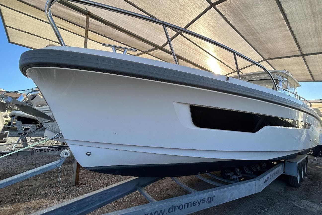 2022 Nimbus T11 boat on trailer under canopy, side view.