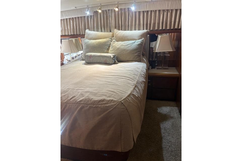 Luxurious bedroom interior of 1990 Californian 45 Motor Yacht with elegant bedding and lighting.