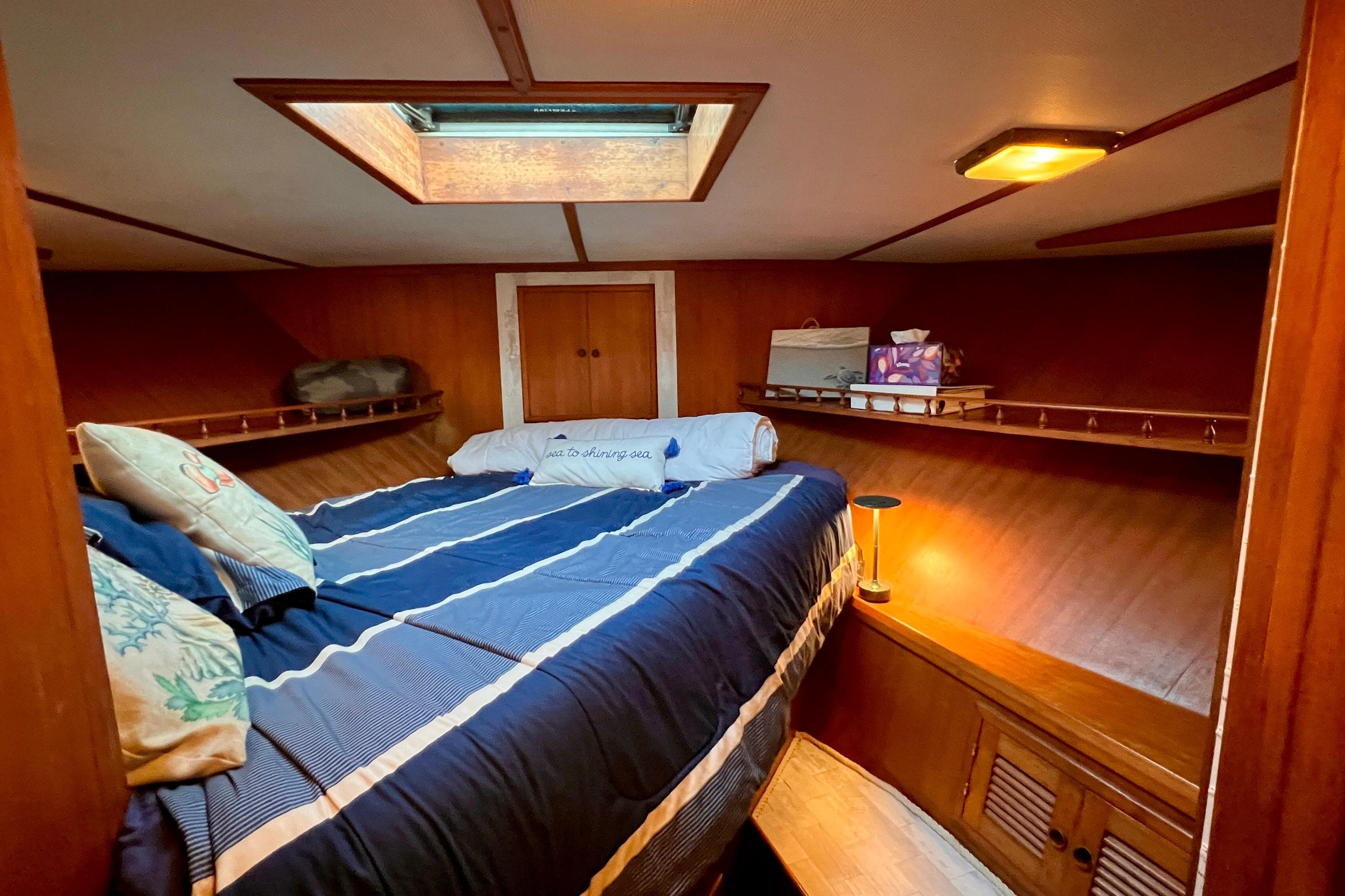 Cozy cabin interior of 1985 Heritage East 40 Sundeck Trawler with skylight and bedding.