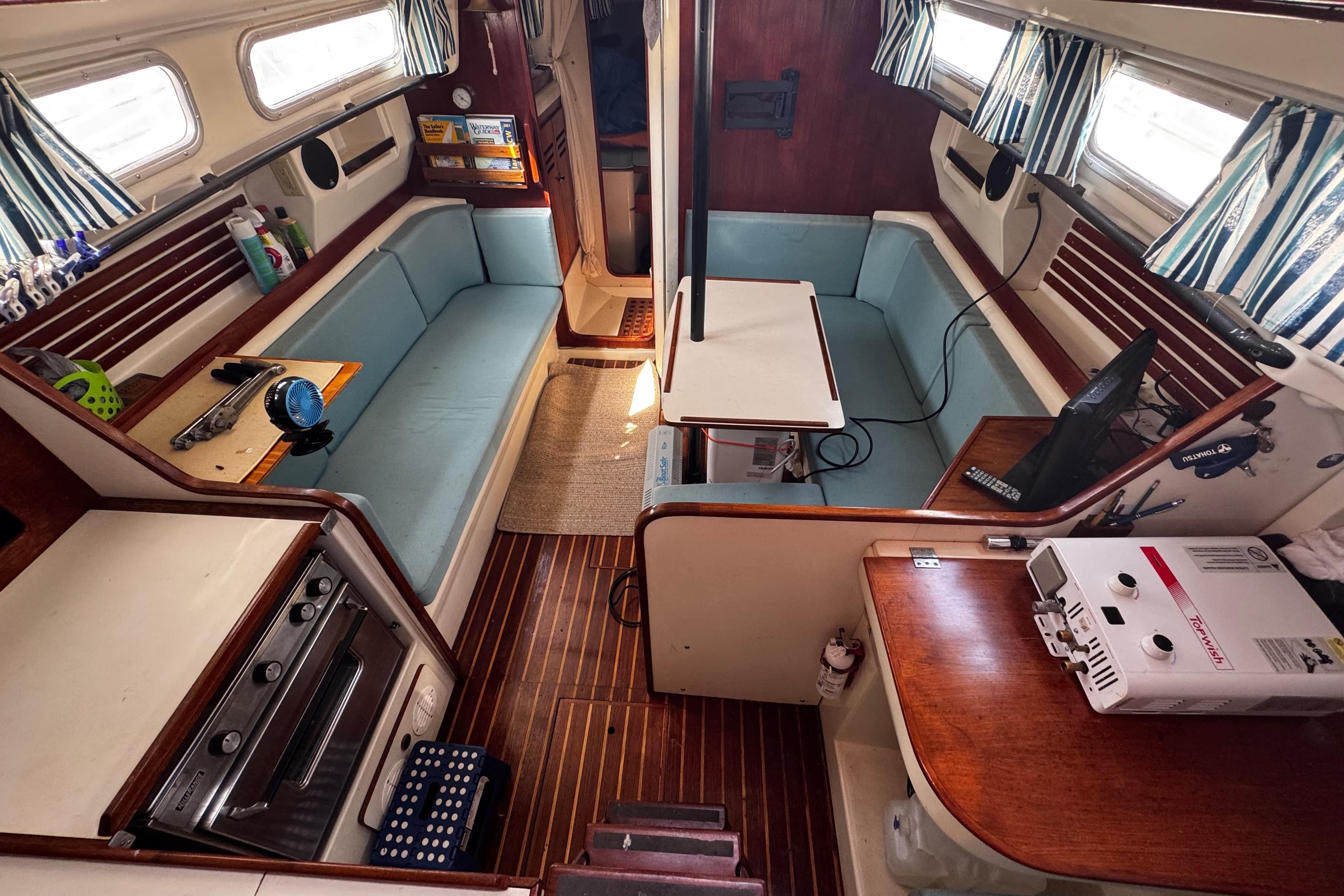 Interior of a 1982 Pearson 323 sailboat with cozy seating and nautical decor.