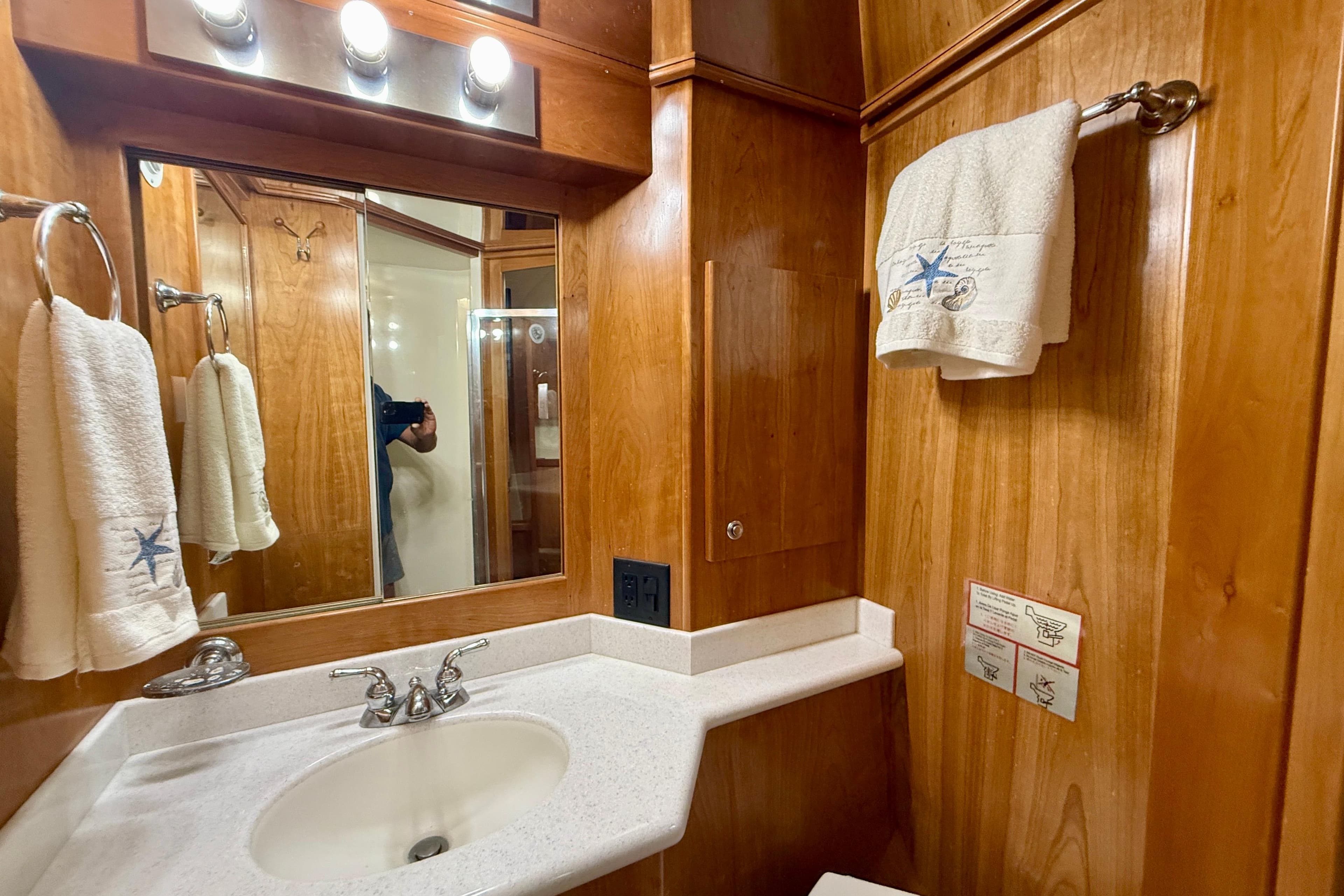 Luxurious wooden bathroom interior of 2007 Navigator 44 Classic yacht with elegant fixtures.