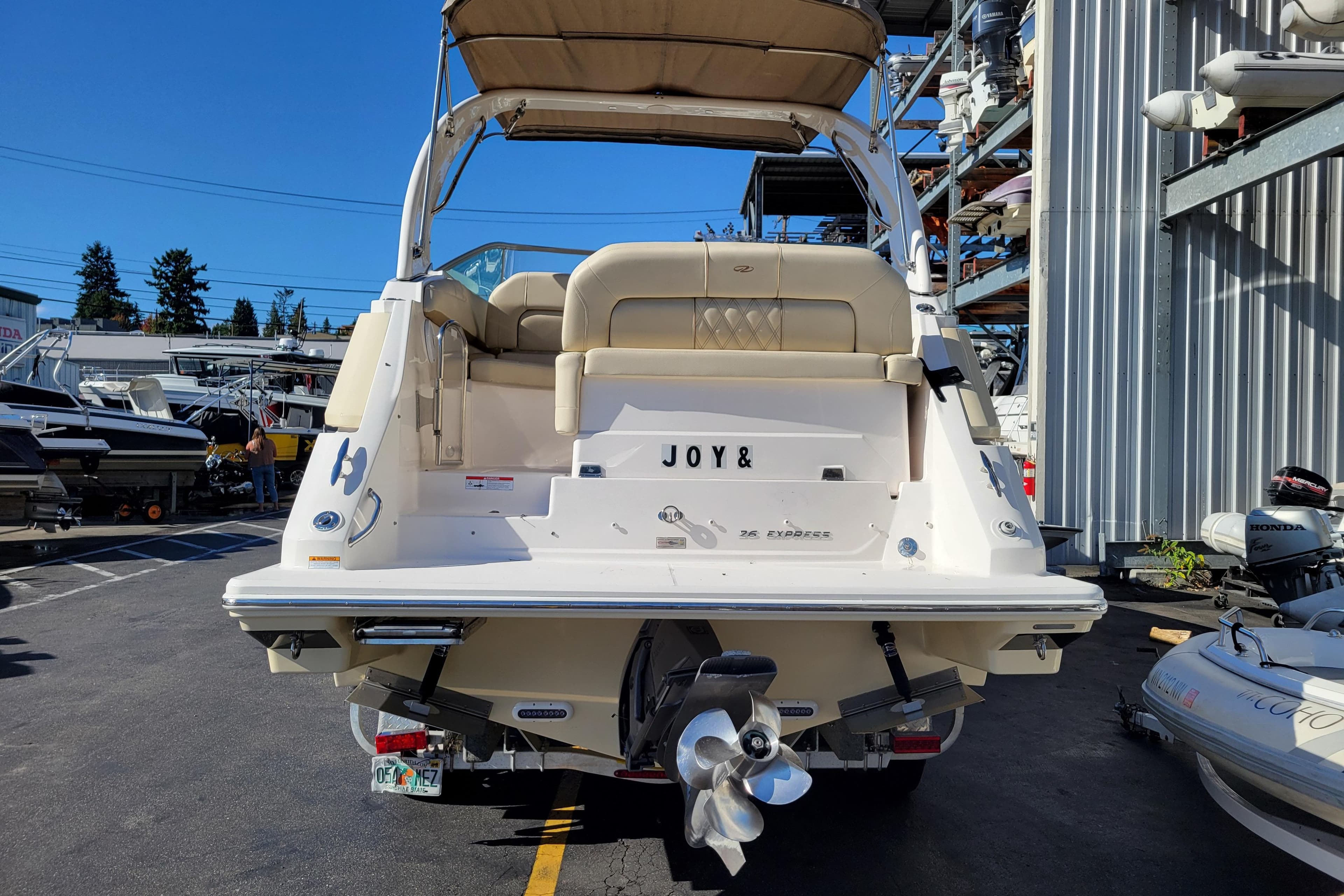 2018 Regal 26 Express boat docked, rear view with "JOY&" nameplate.