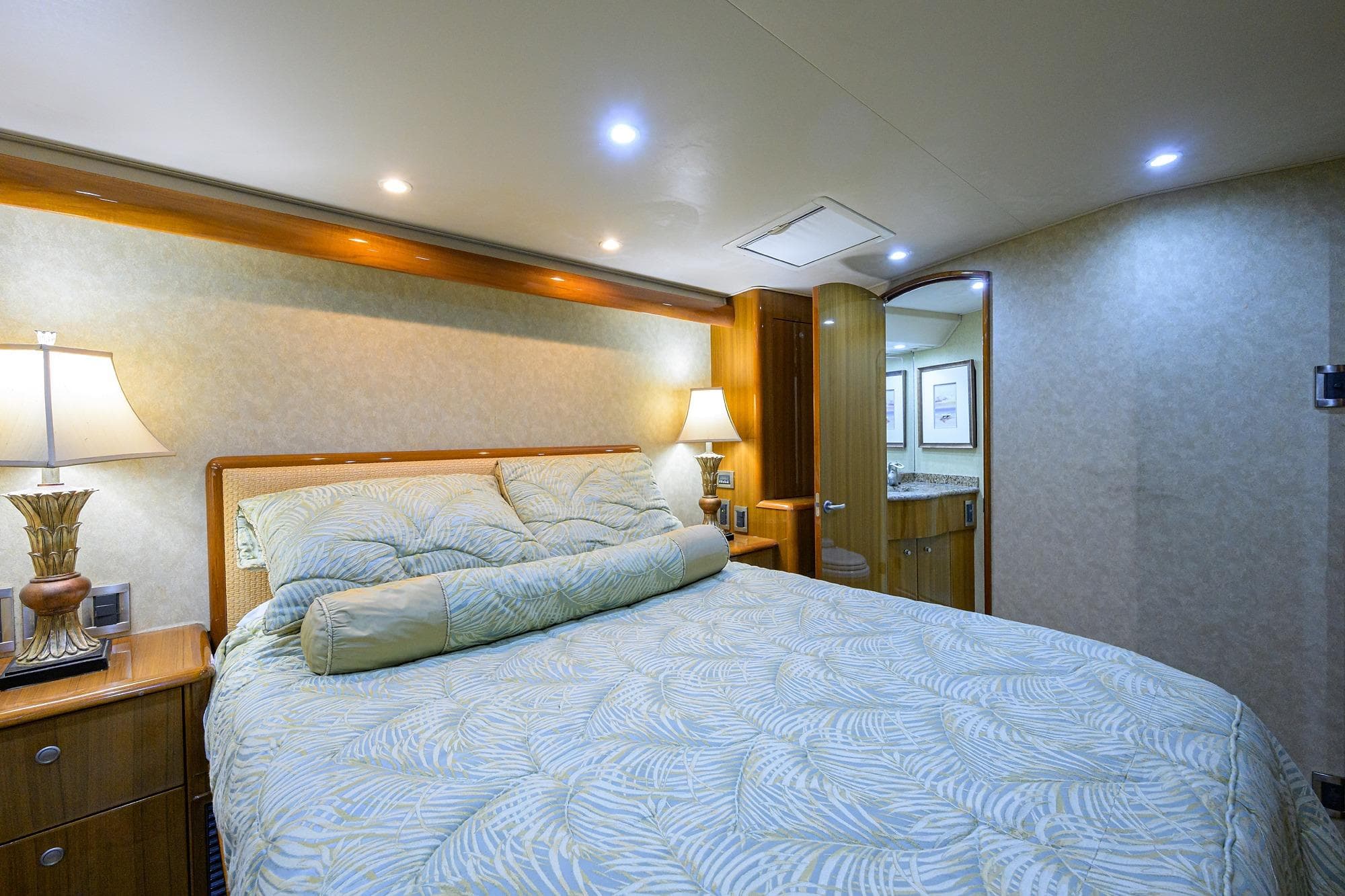 Luxurious bedroom interior of 2007 Viking 56 Convertible yacht with elegant bedding and lighting.