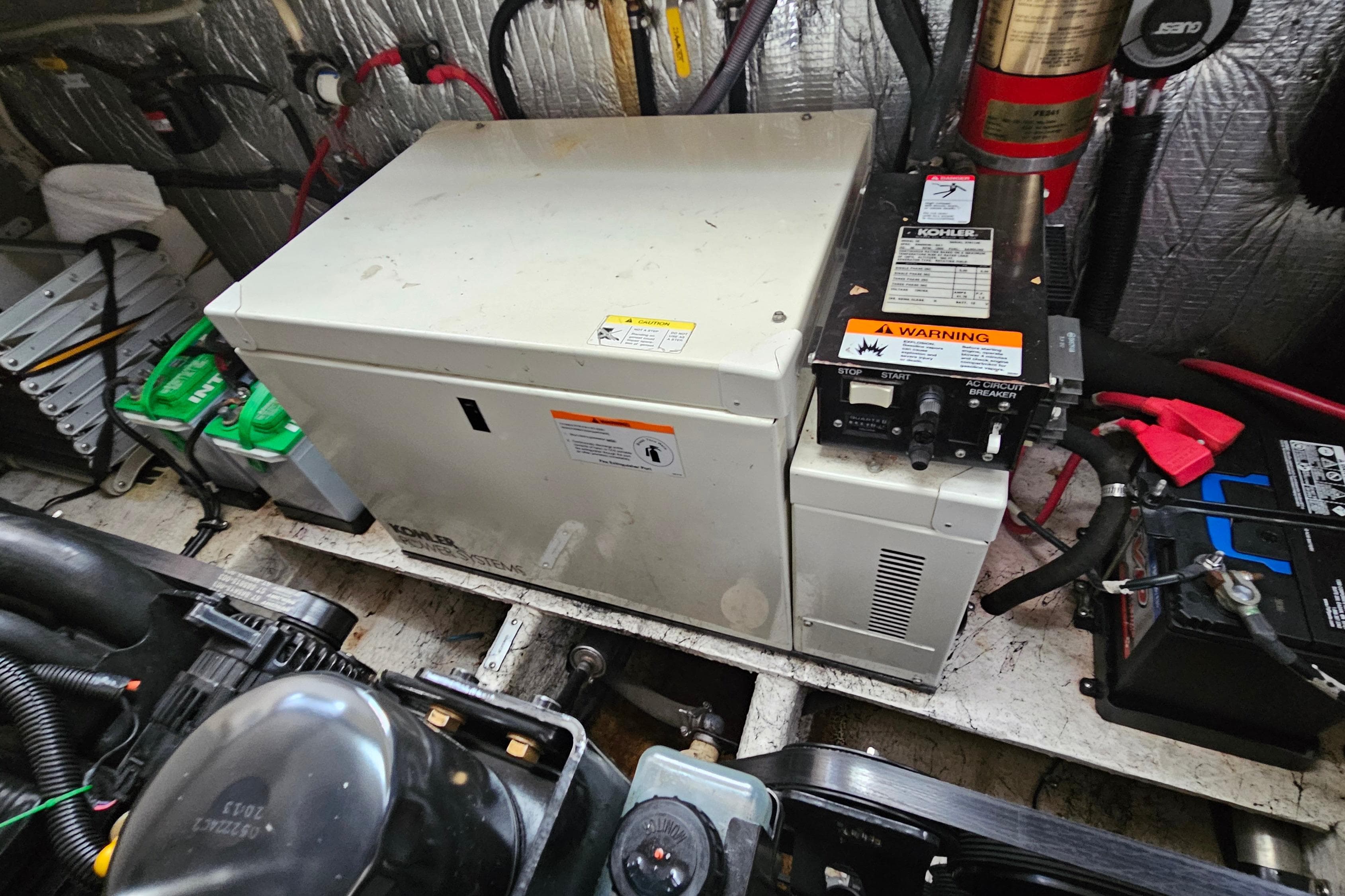 Engine room of 2004 Rinker Fiesta Vee 312 with Kohler generator and batteries.
