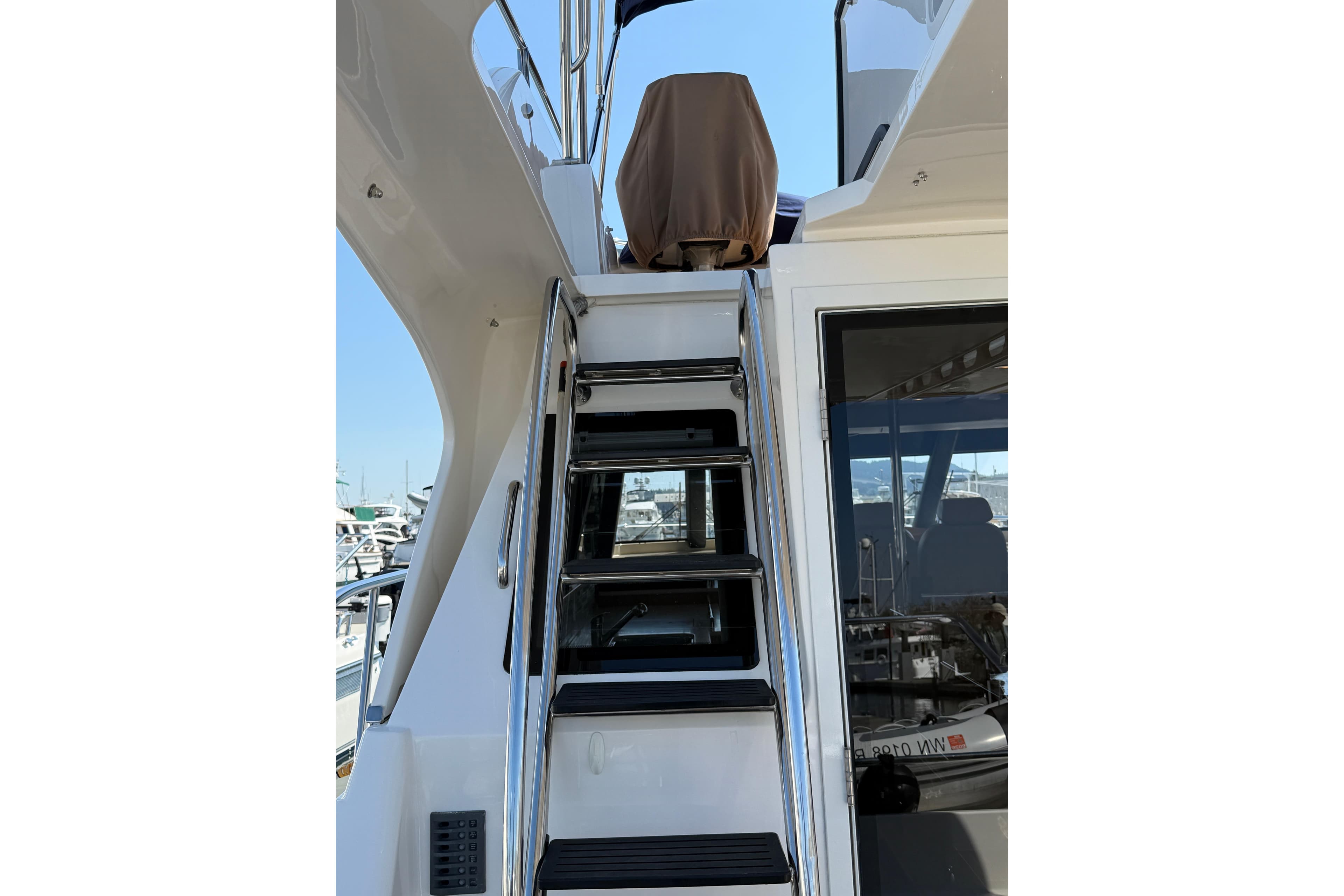 Staircase on 2017 Aspen C120 yacht leading to upper deck, marina view.