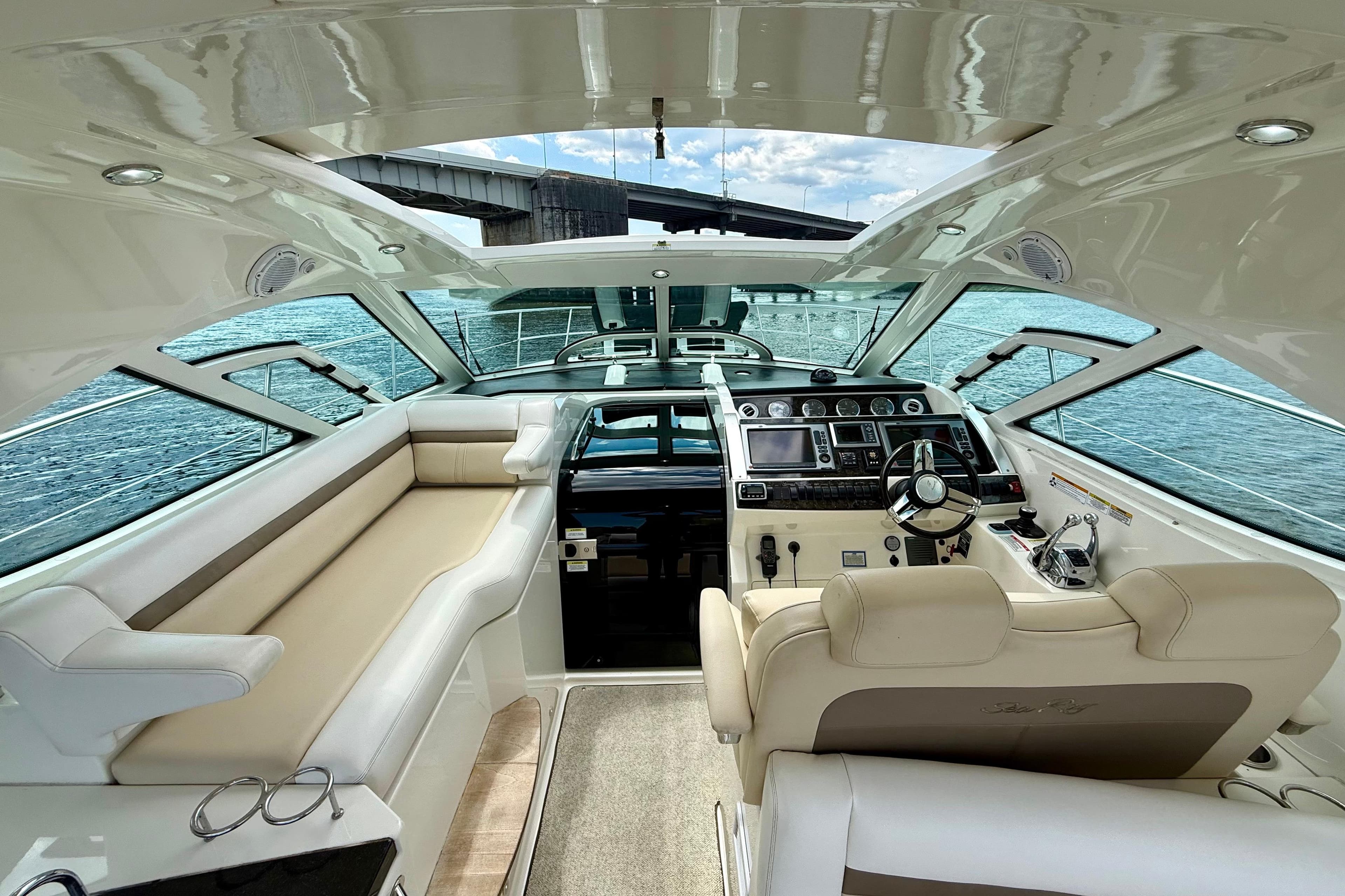 Luxurious interior of 2012 Sea Ray 410 Sundancer yacht with helm and seating area.