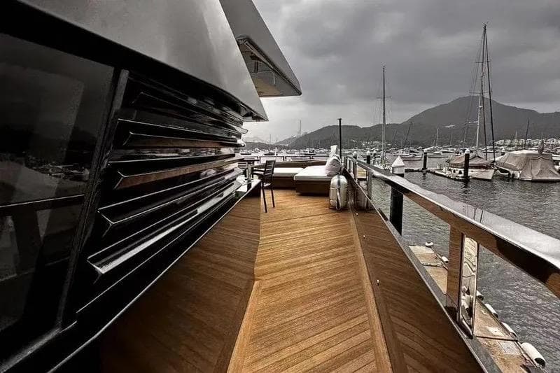 Luxurious Evadne ROCK 85 yacht deck with wooden flooring, docked in a scenic marina.