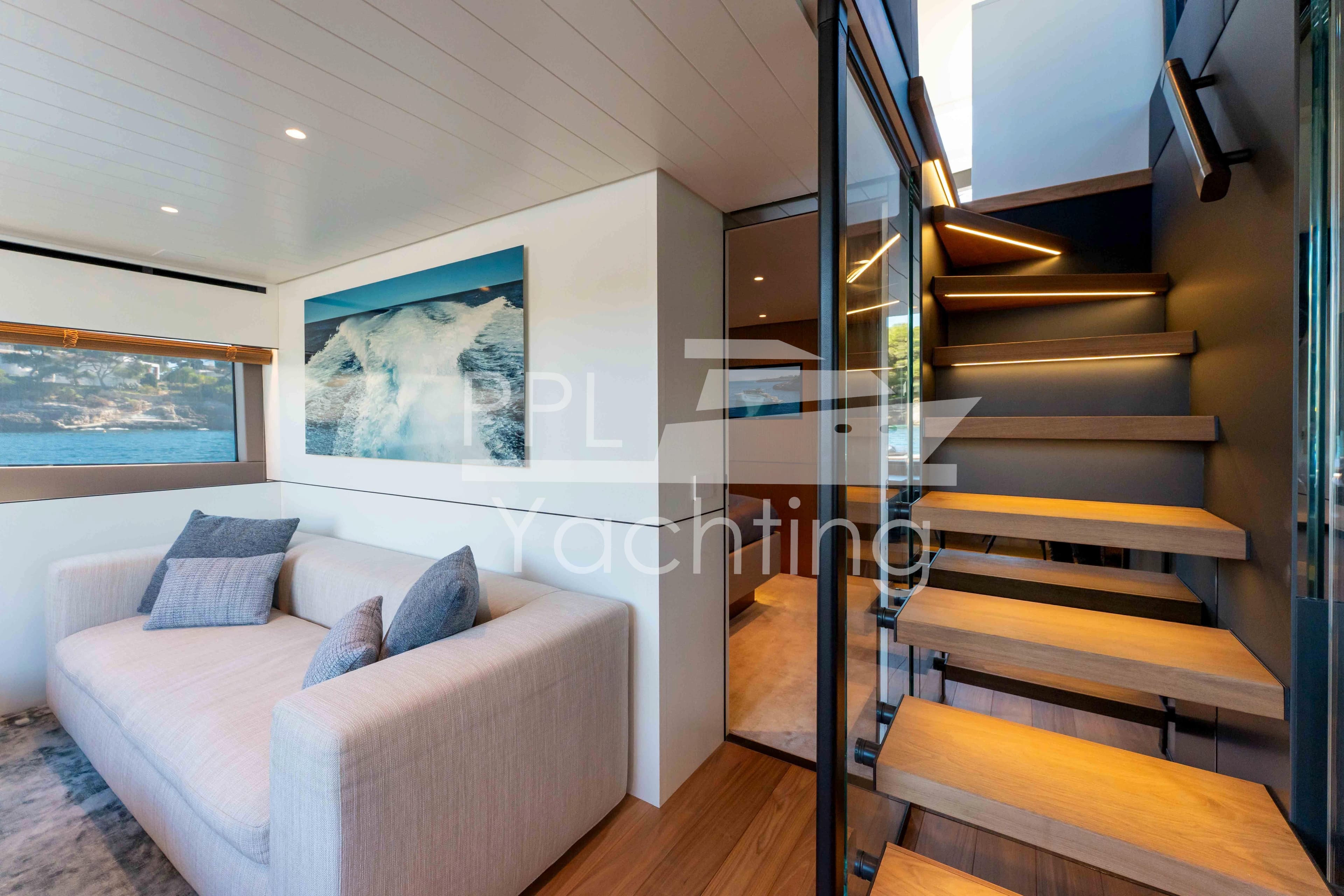 Luxurious interior of 2024 Bluegame BGX63 yacht with modern staircase and cozy seating area.