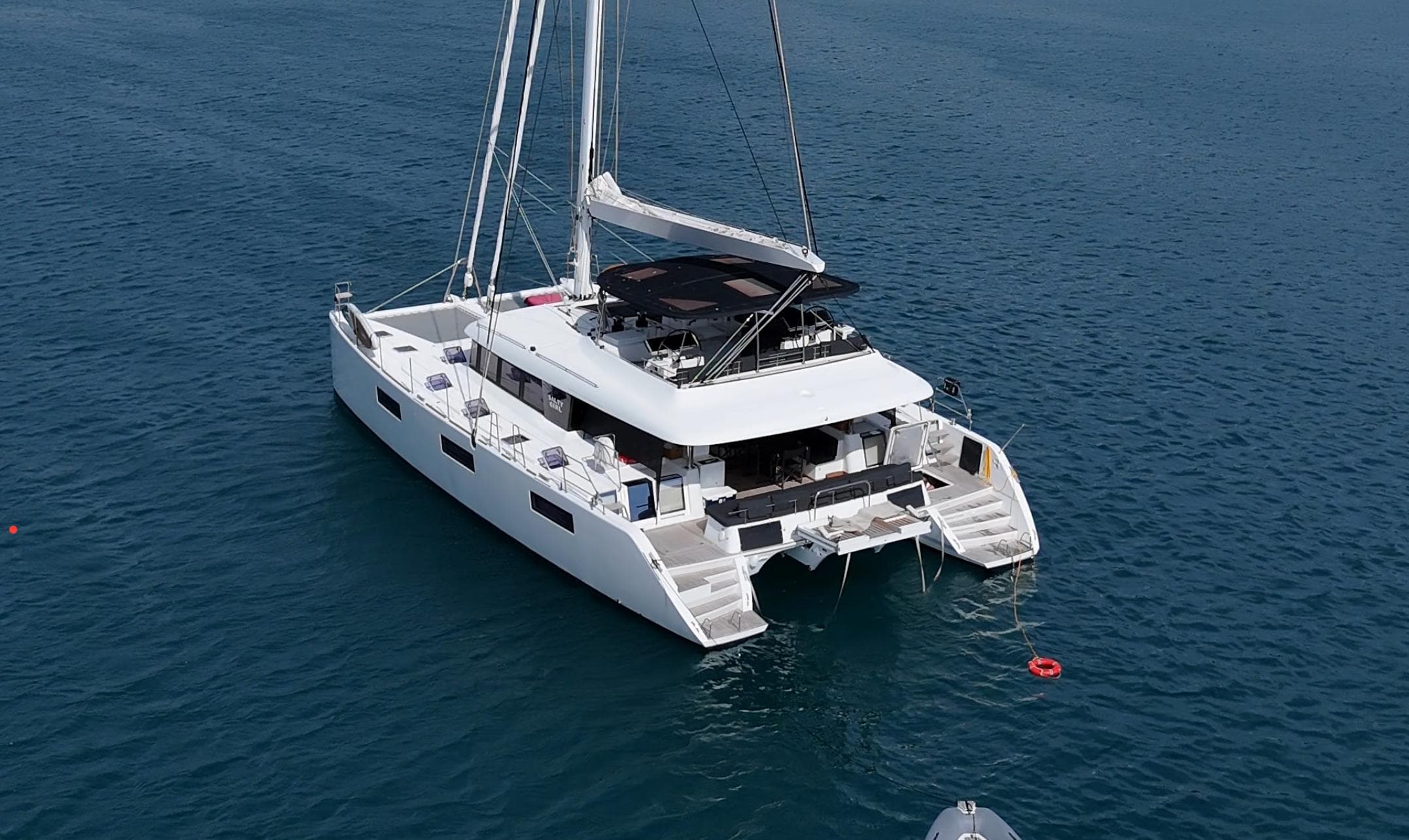 2017 Lagoon 620 Essence catamaran sailing on calm blue waters.
