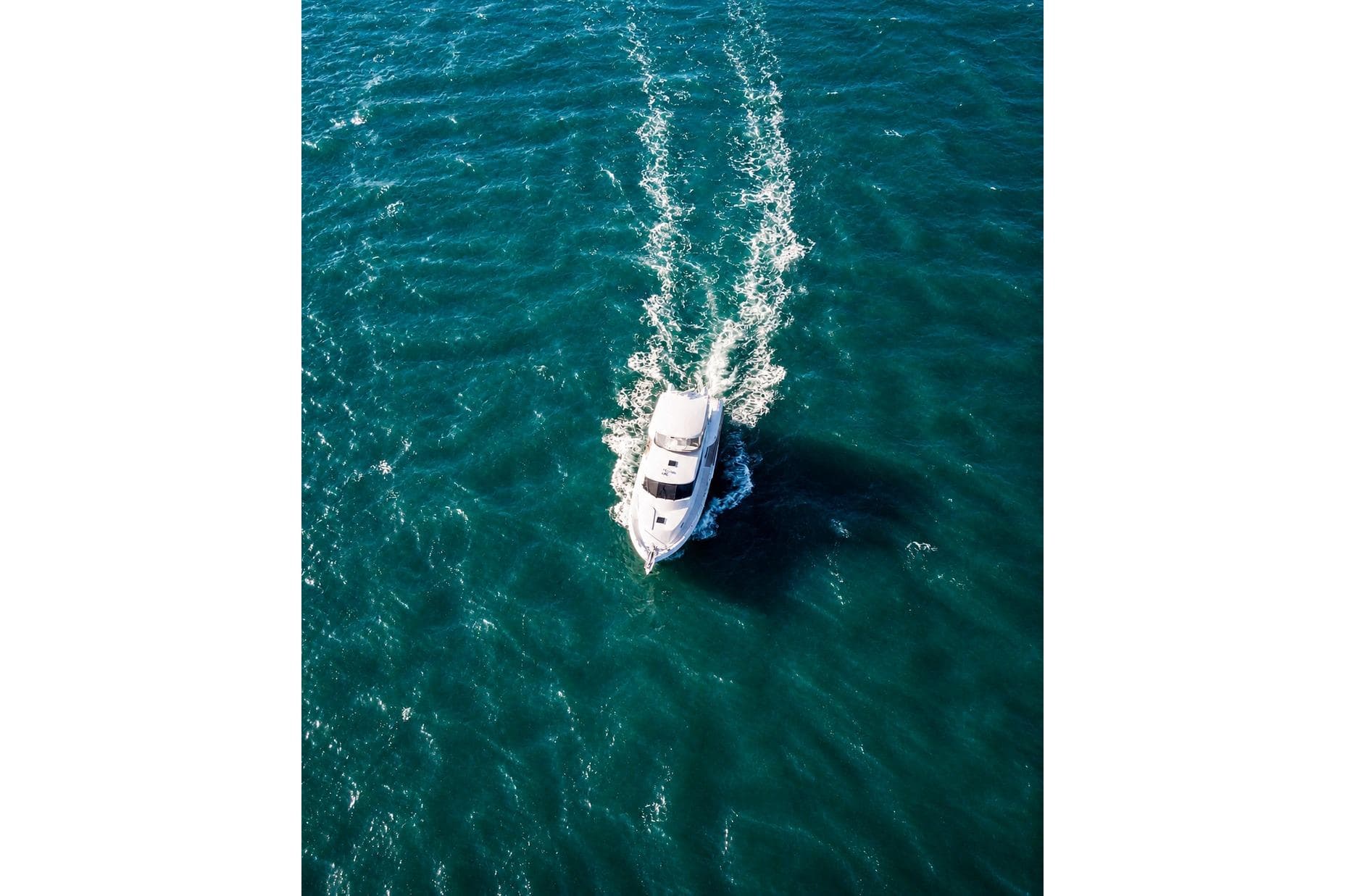 Aerial view of 2005 Symbol 58 Pilothouse yacht cruising on blue ocean waters.