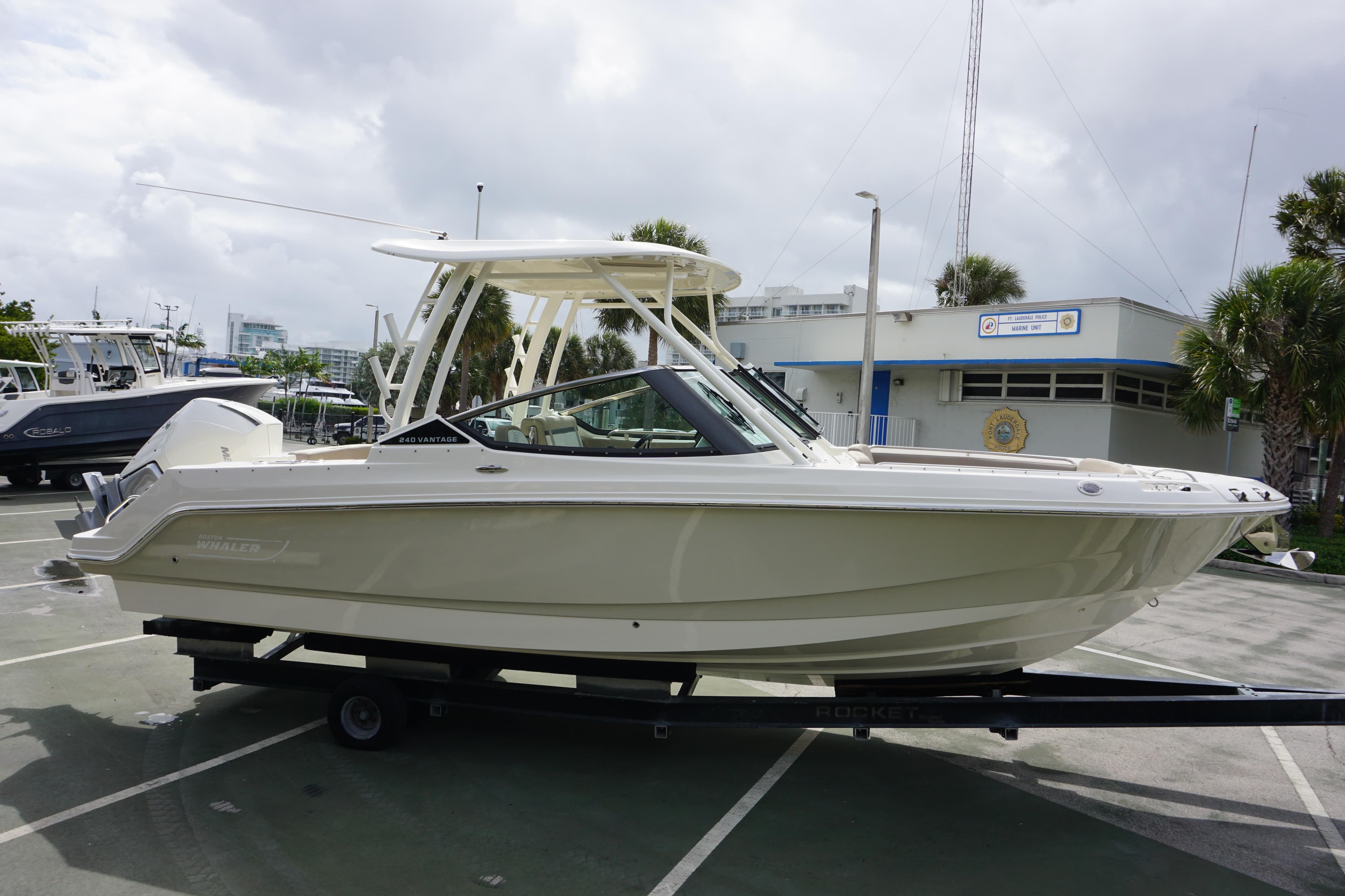 2026 Boston Whaler 240 Vantage boat on trailer in marina parking lot.