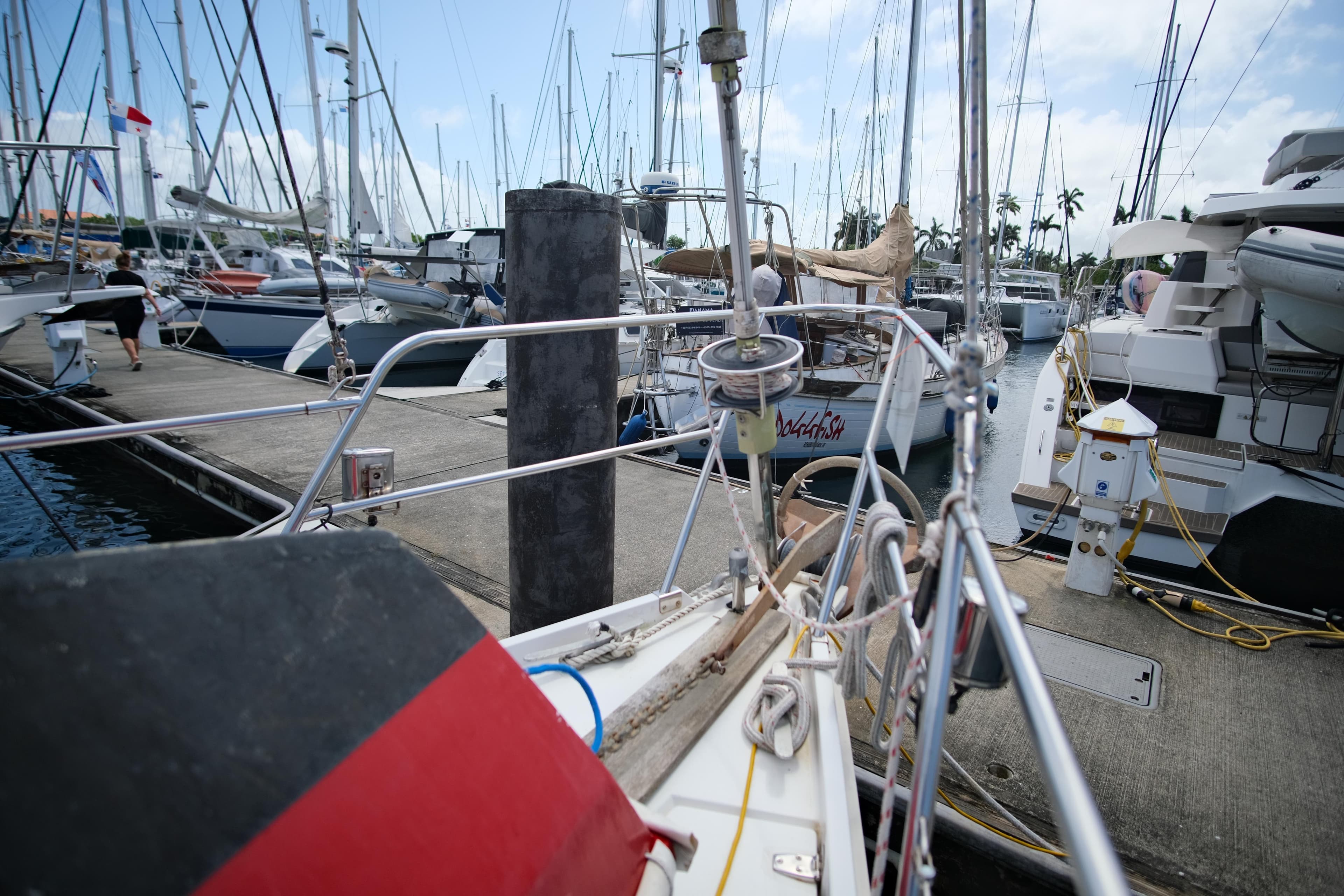 1985 Amel Sharki sailboat docked in a marina with other boats.