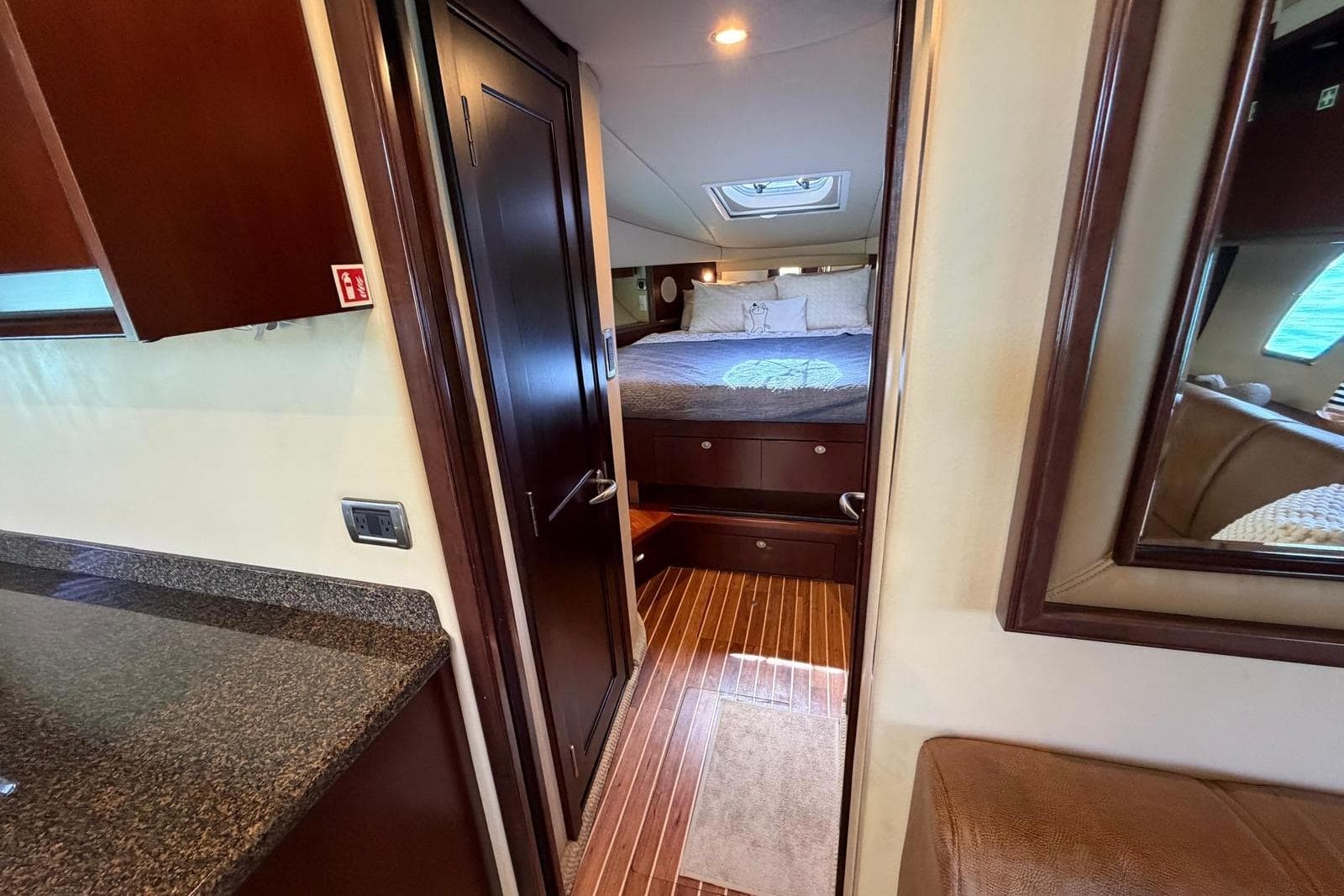 Luxurious interior of 2006 Sea Ray 480 Sundancer yacht with cozy bedroom and elegant wood finishes.