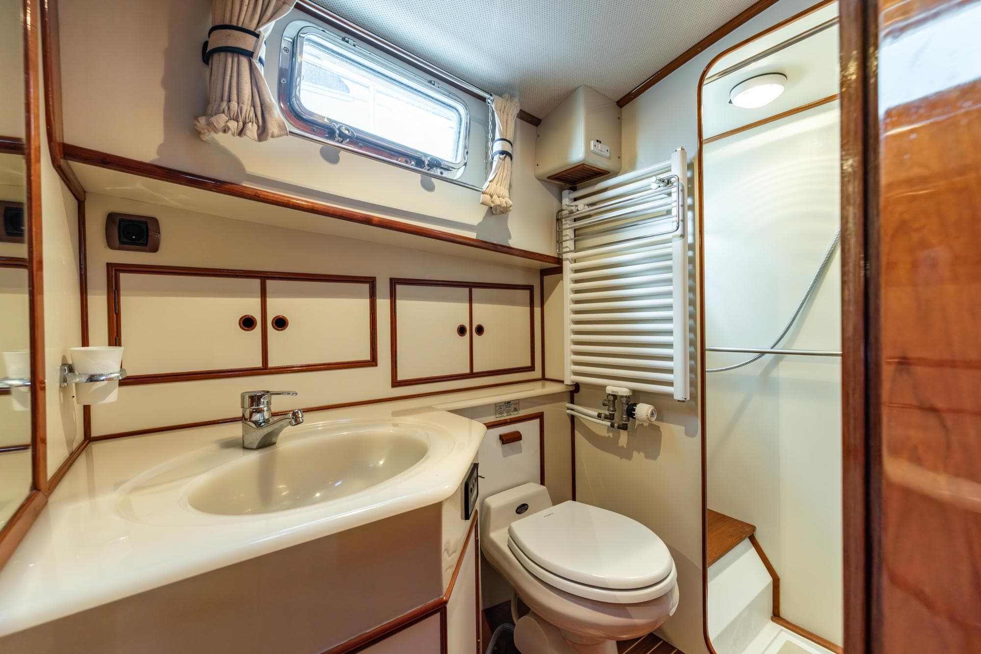Bathroom interior of 1999 Grand Banks 43 Eastbay FB yacht, featuring sink, toilet, and shower.