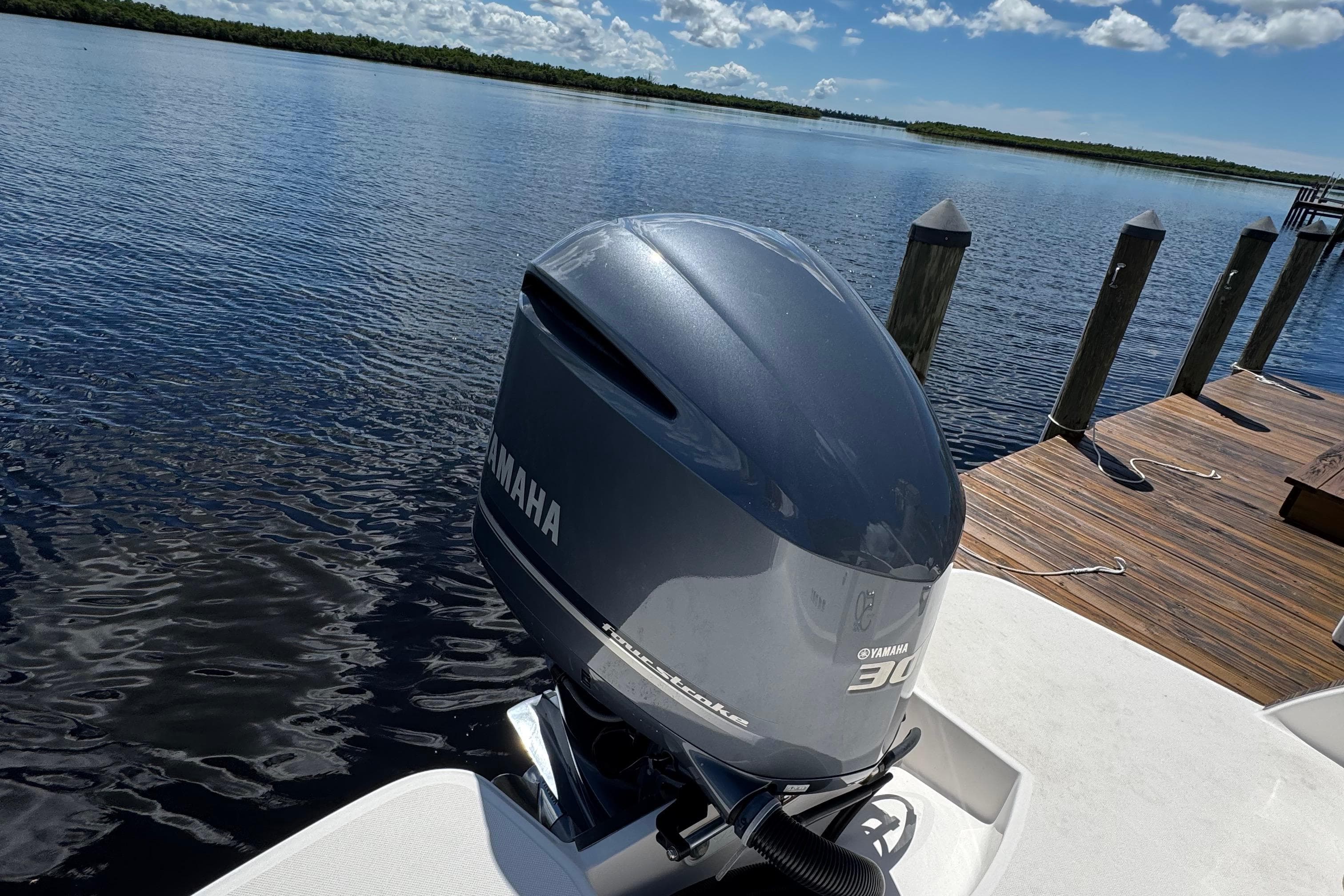 2021 Regal 26 OBX with Yamaha outboard motor docked by a serene lake.