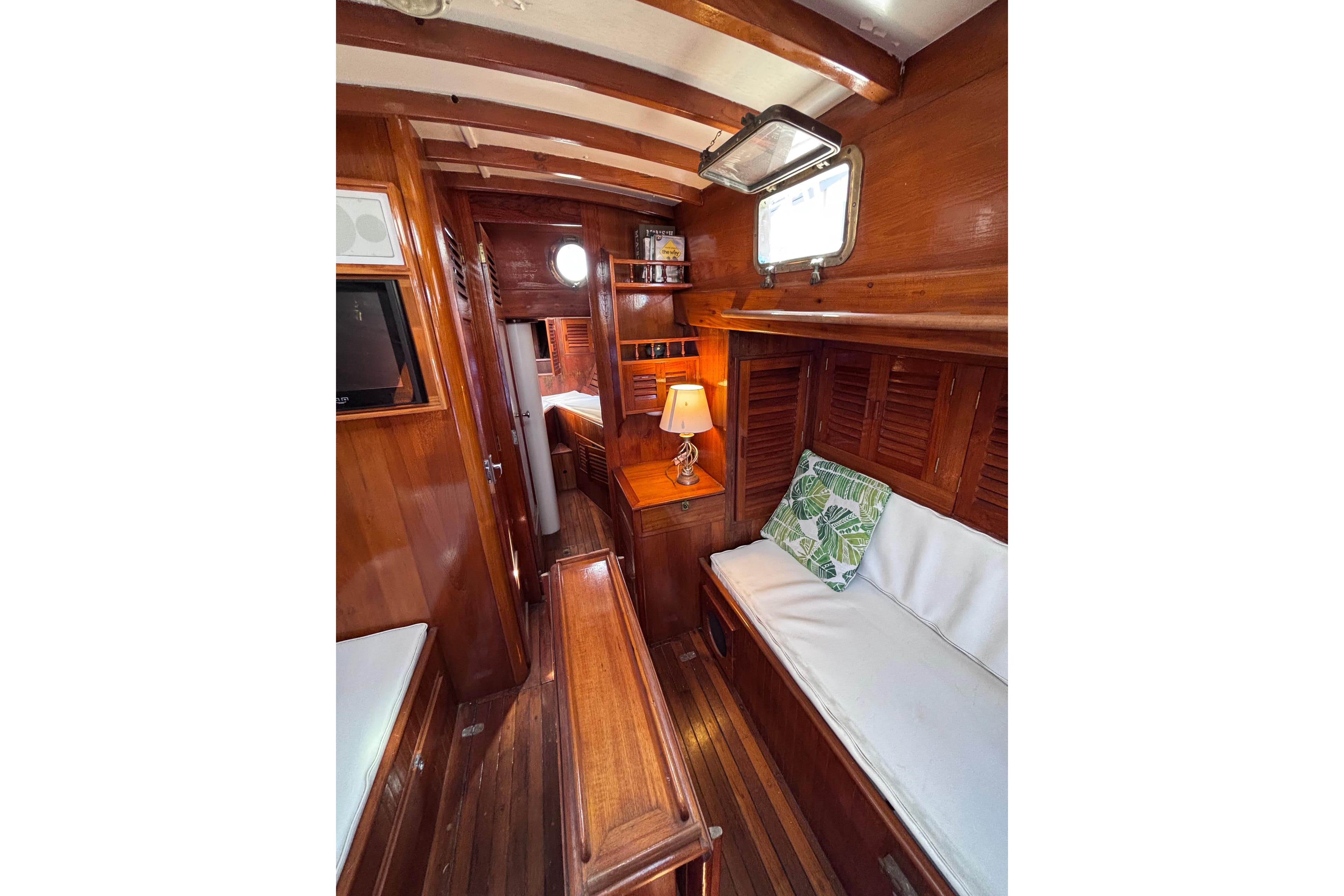 Cozy 1970 Chen boat interior with wooden furnishings and cushioned seating.