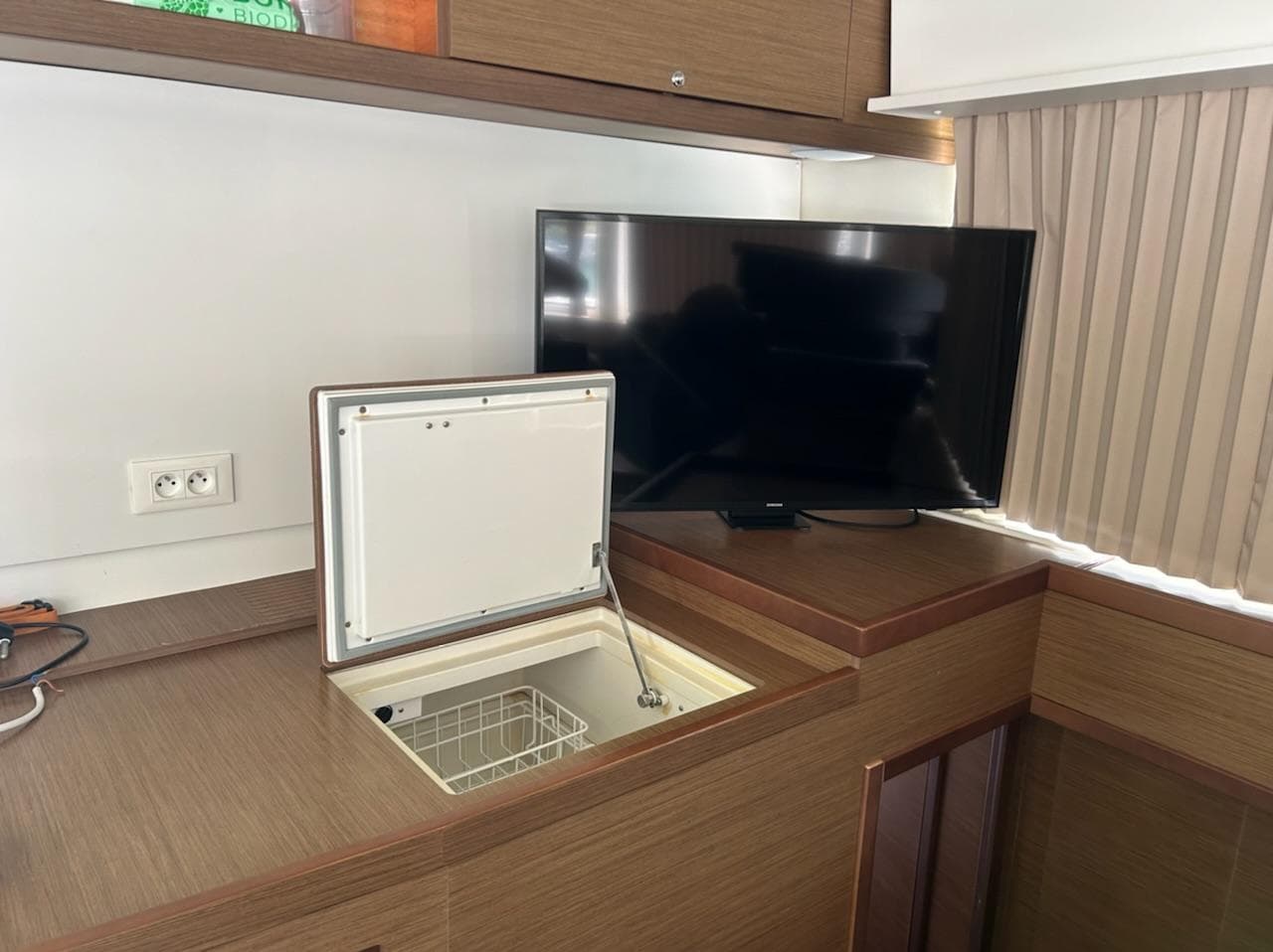 Interior of 2018 Lagoon 42 yacht with TV and built-in storage.