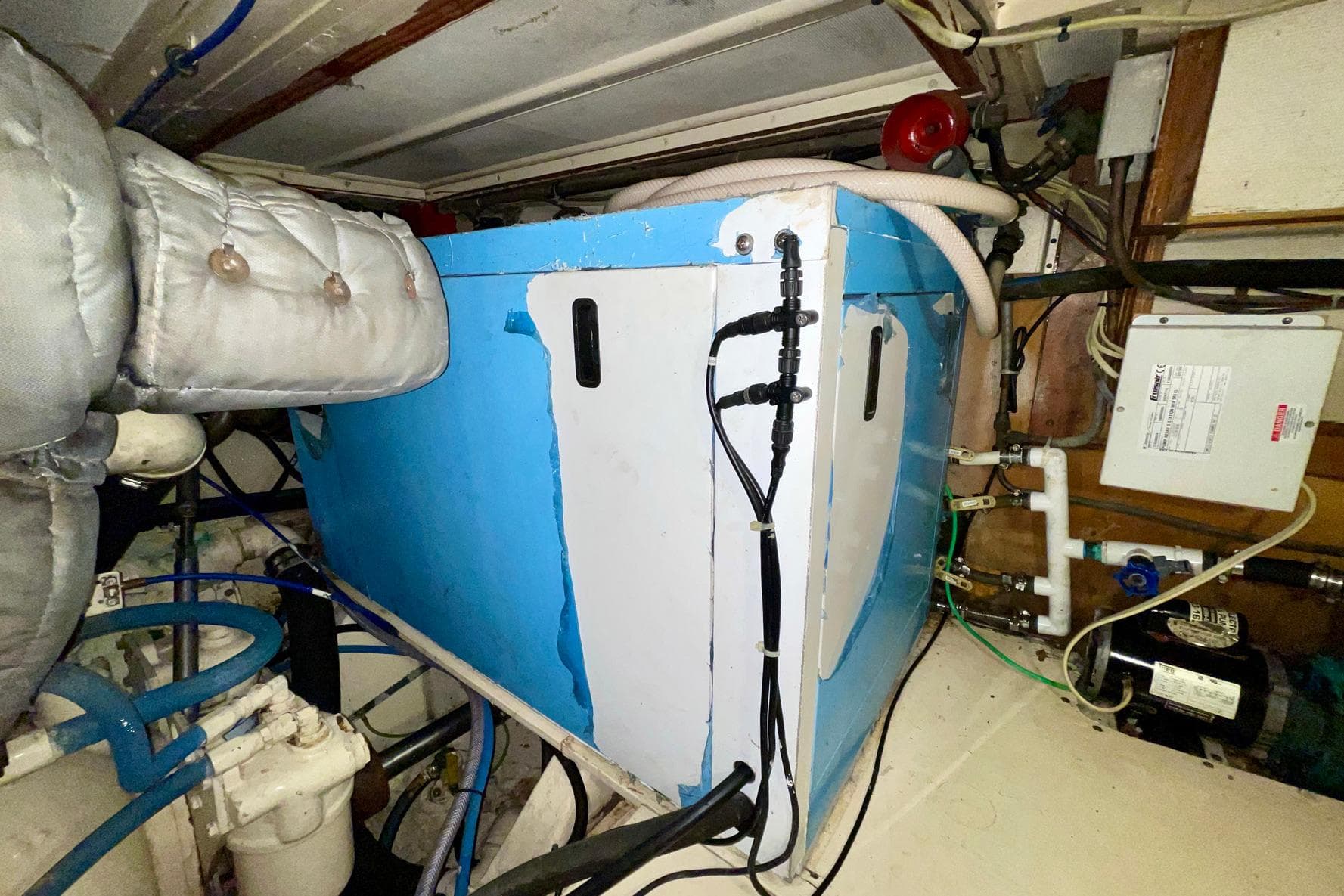 1981 Hatteras 48 Motor Yacht engine room with blue machinery and wiring.