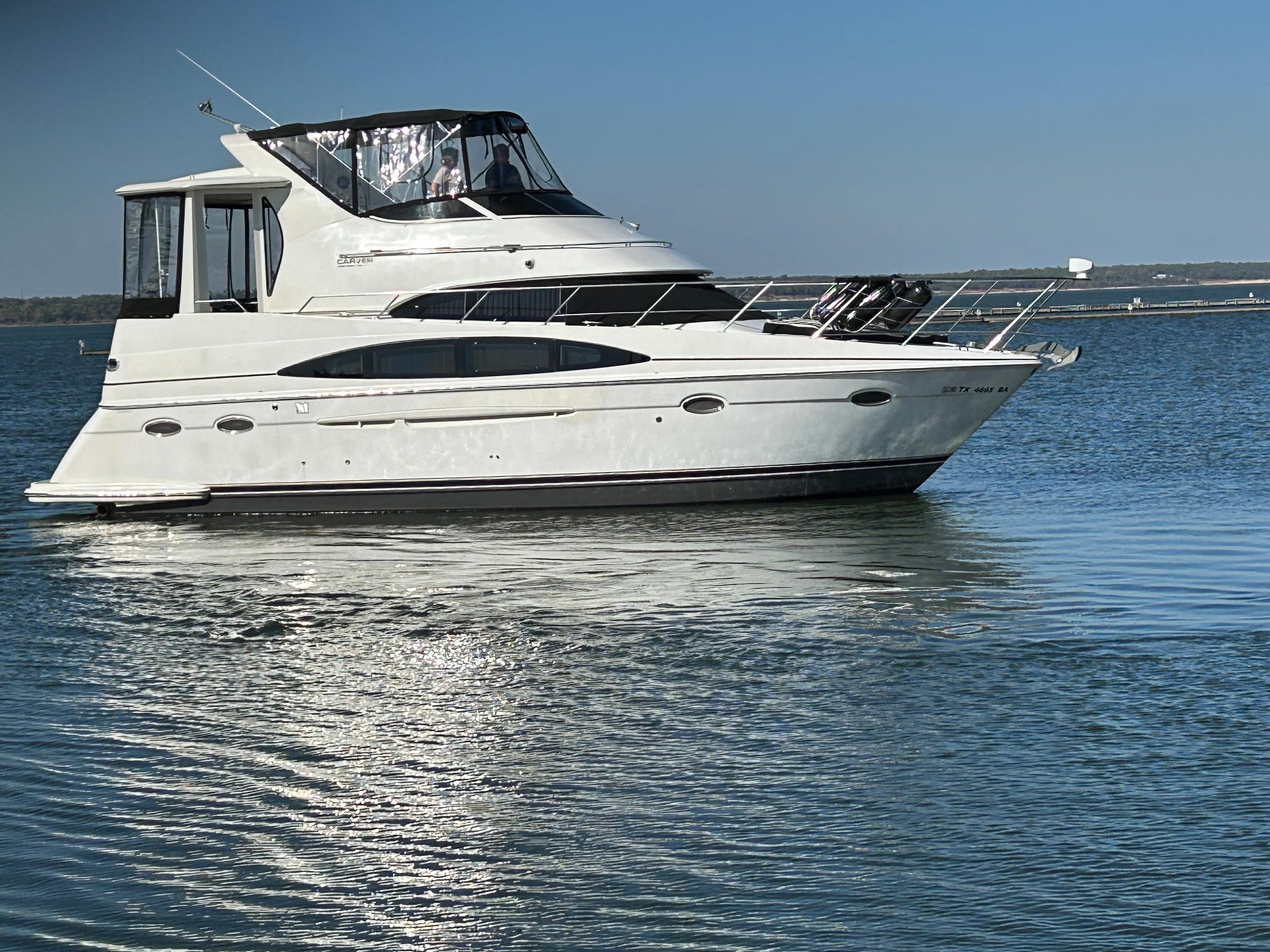 2000 Carver 396 yacht on calm water under clear blue sky.