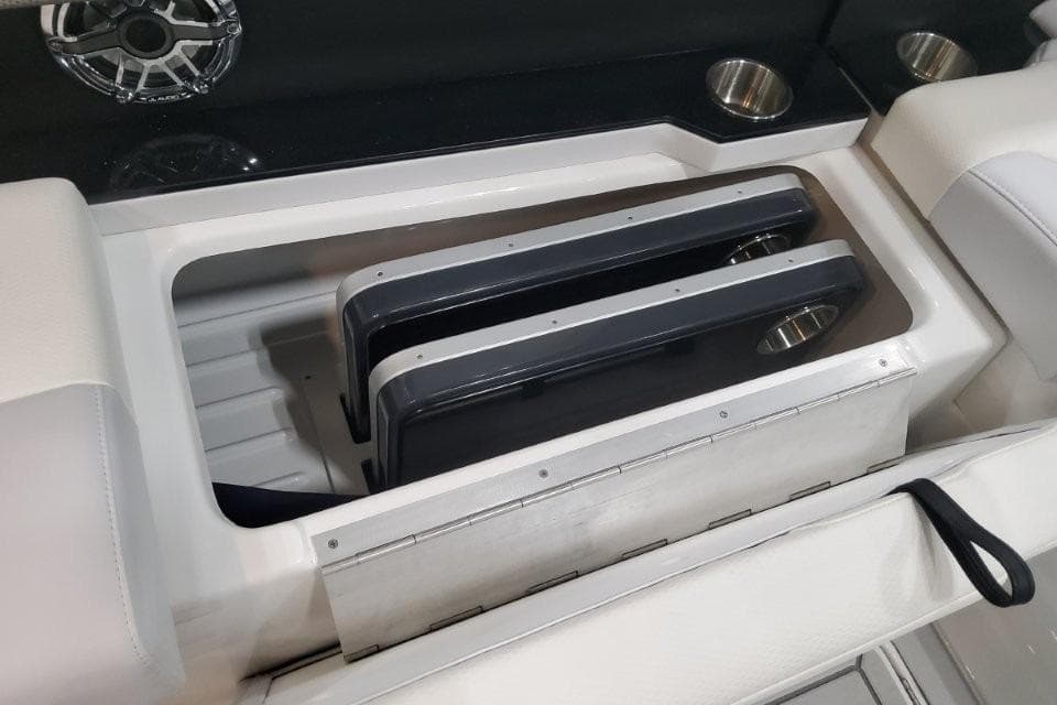 Storage compartment in 2026 Formula 310 Bowrider boat with cup holders and speaker.