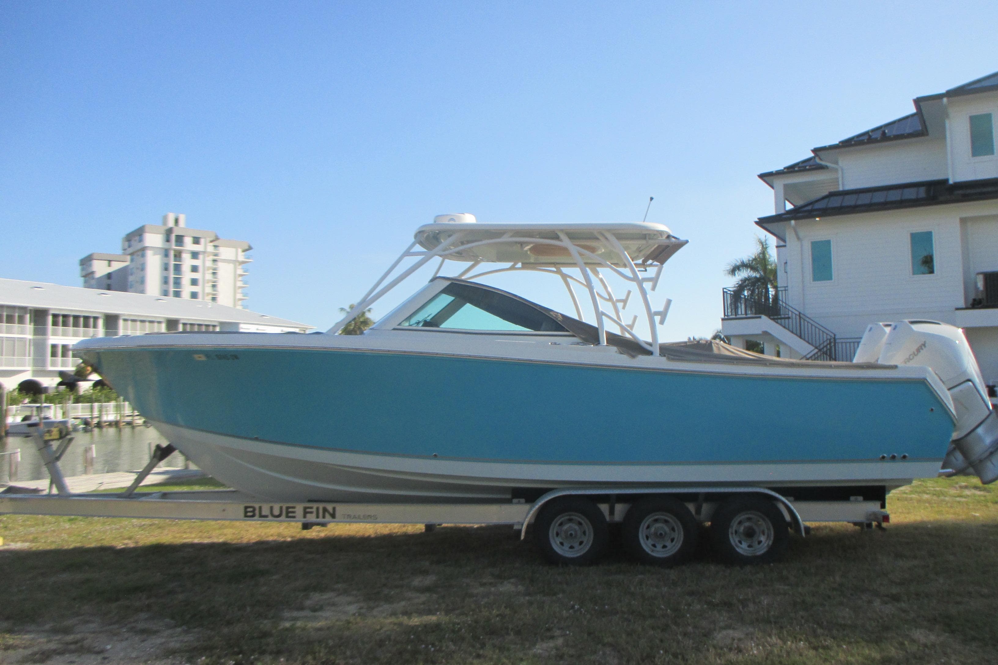2019 Sailfish 325 DC boat on trailer near waterfront homes.