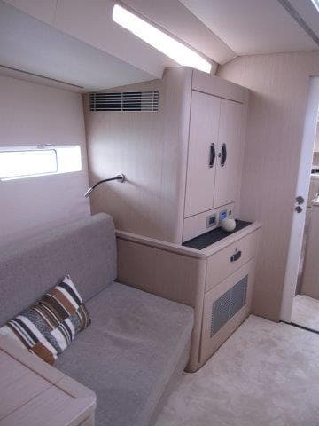 Modern interior of 2024 Jeanneau 55 yacht with cozy seating area.