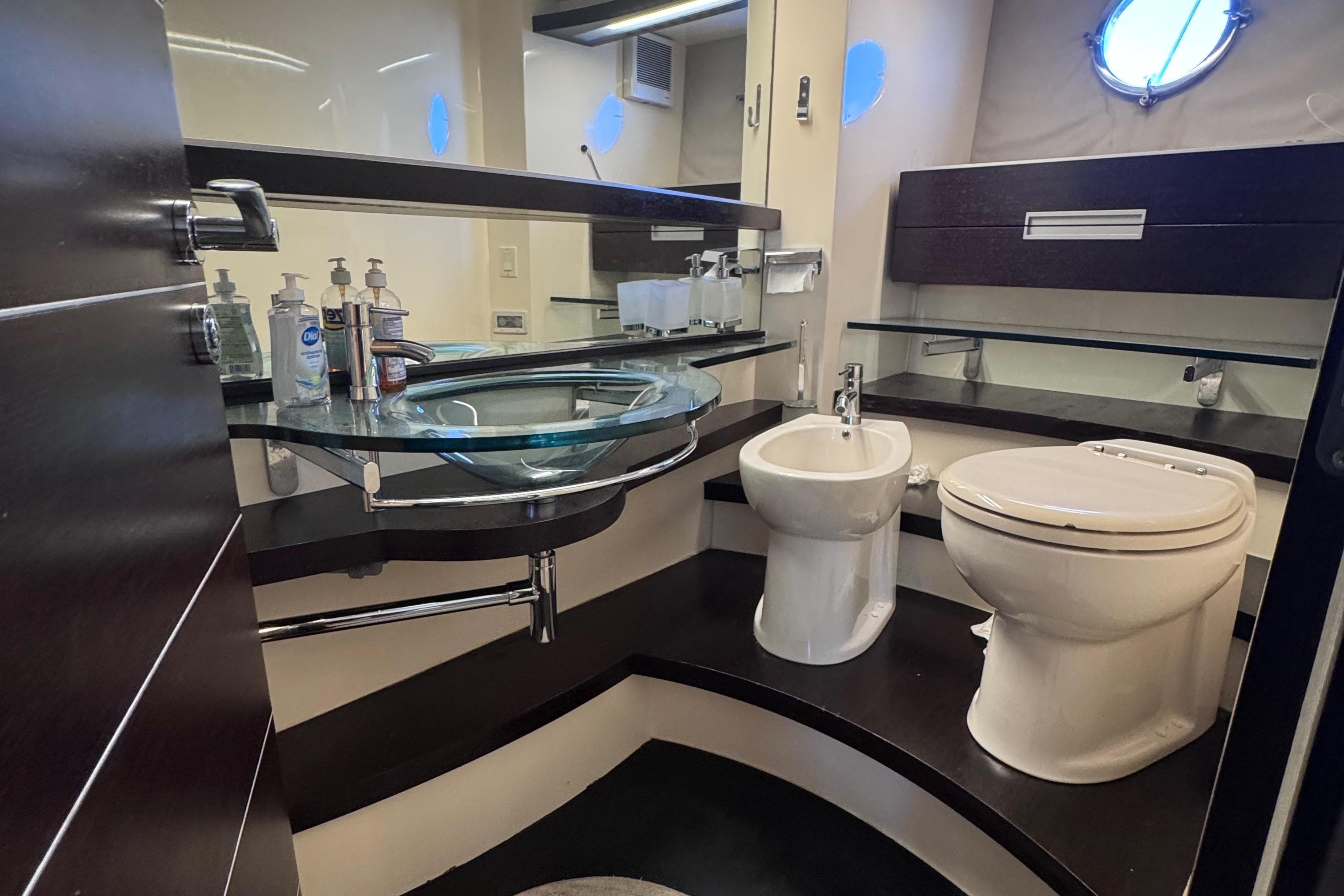 Luxurious bathroom in a 2006 Azimut 68S yacht with modern fixtures and glass sink.
