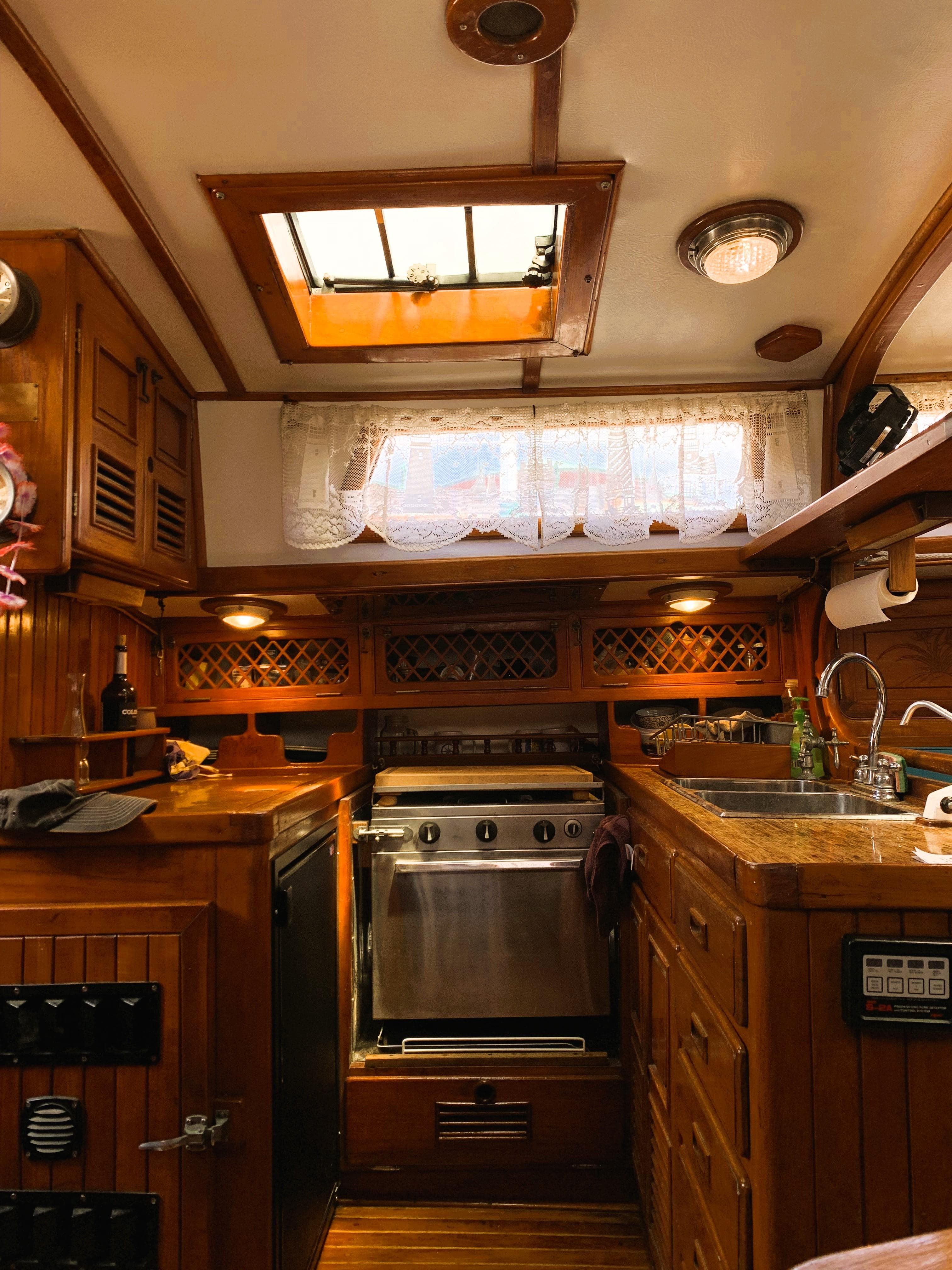 Interior of a 1979 Robert Perry 41 Sloop, featuring a cozy wooden kitchen area.