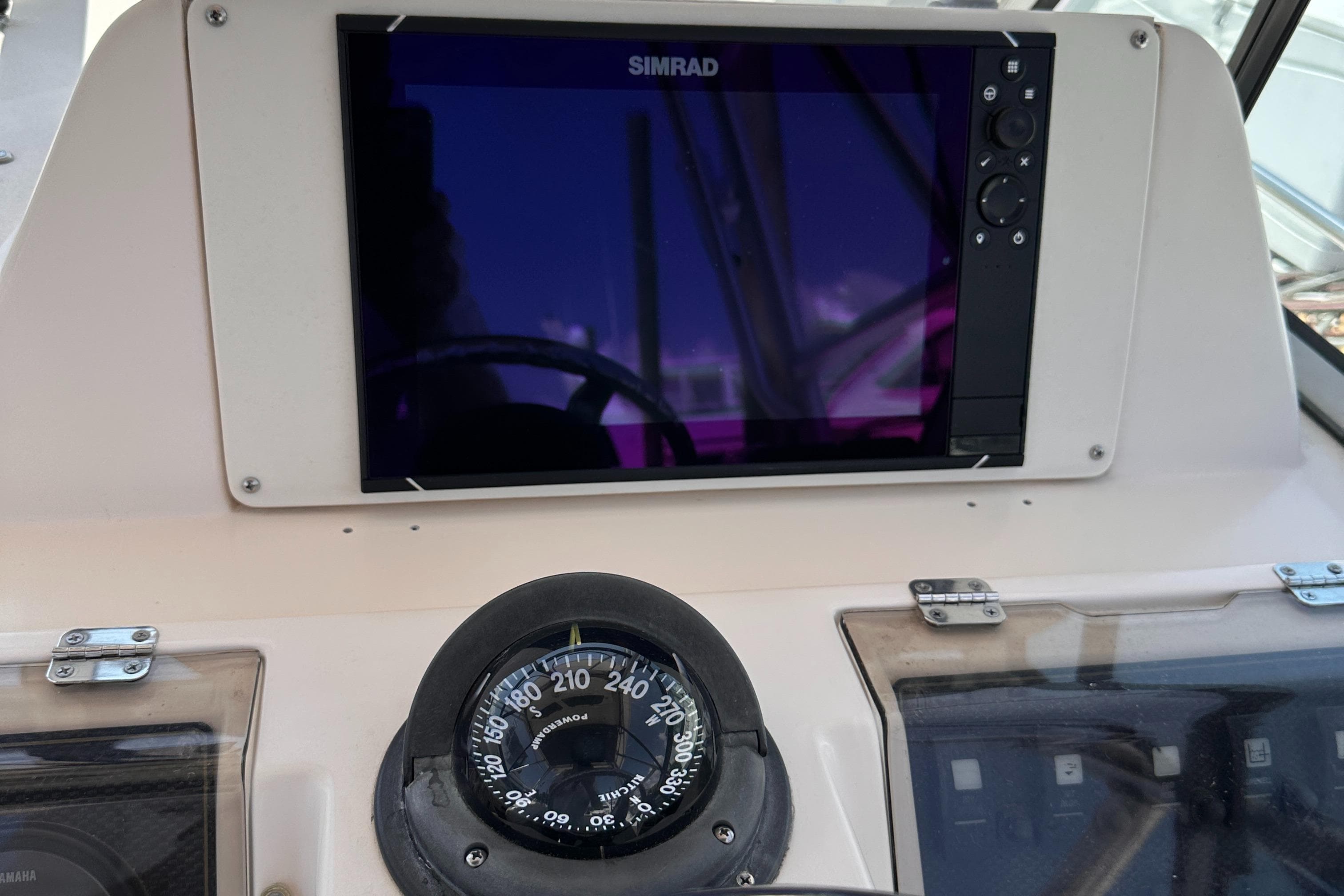 Dashboard of 2004 Grady-White Gulfstream 232 with Simrad display and compass.