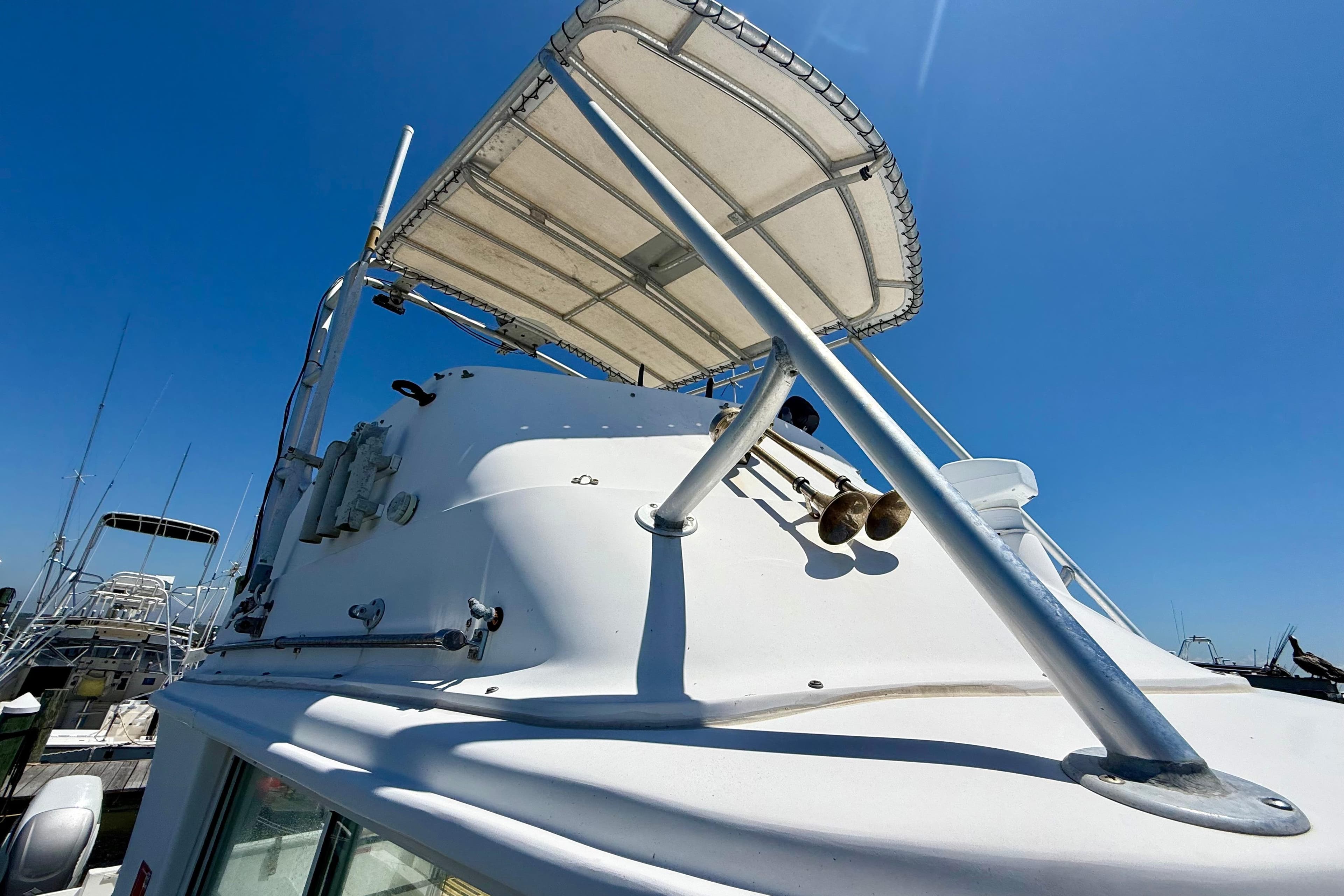 2000 BAJA CRUISER King Cat 340 boat with canopy, docked under clear blue sky.