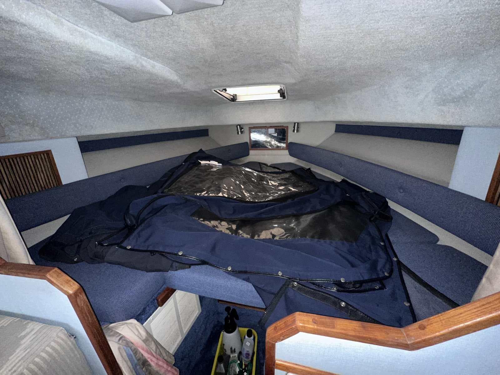 Interior cabin of 1987 Sea Ray 270 Sundancer with blue upholstery and storage space.