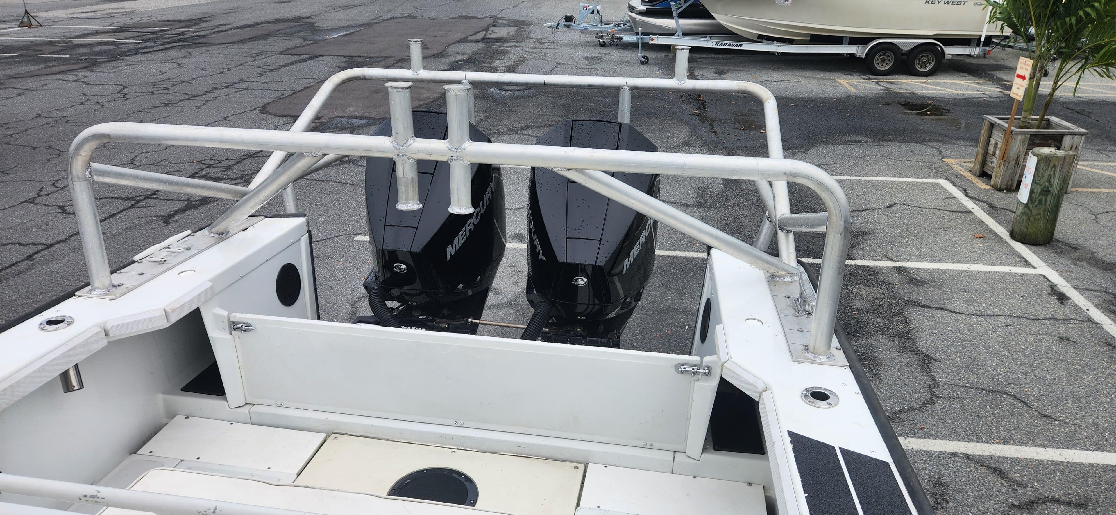 Boston Whaler Justice 24 boat, 2000 model, with dual outboard motors in a parking lot.
