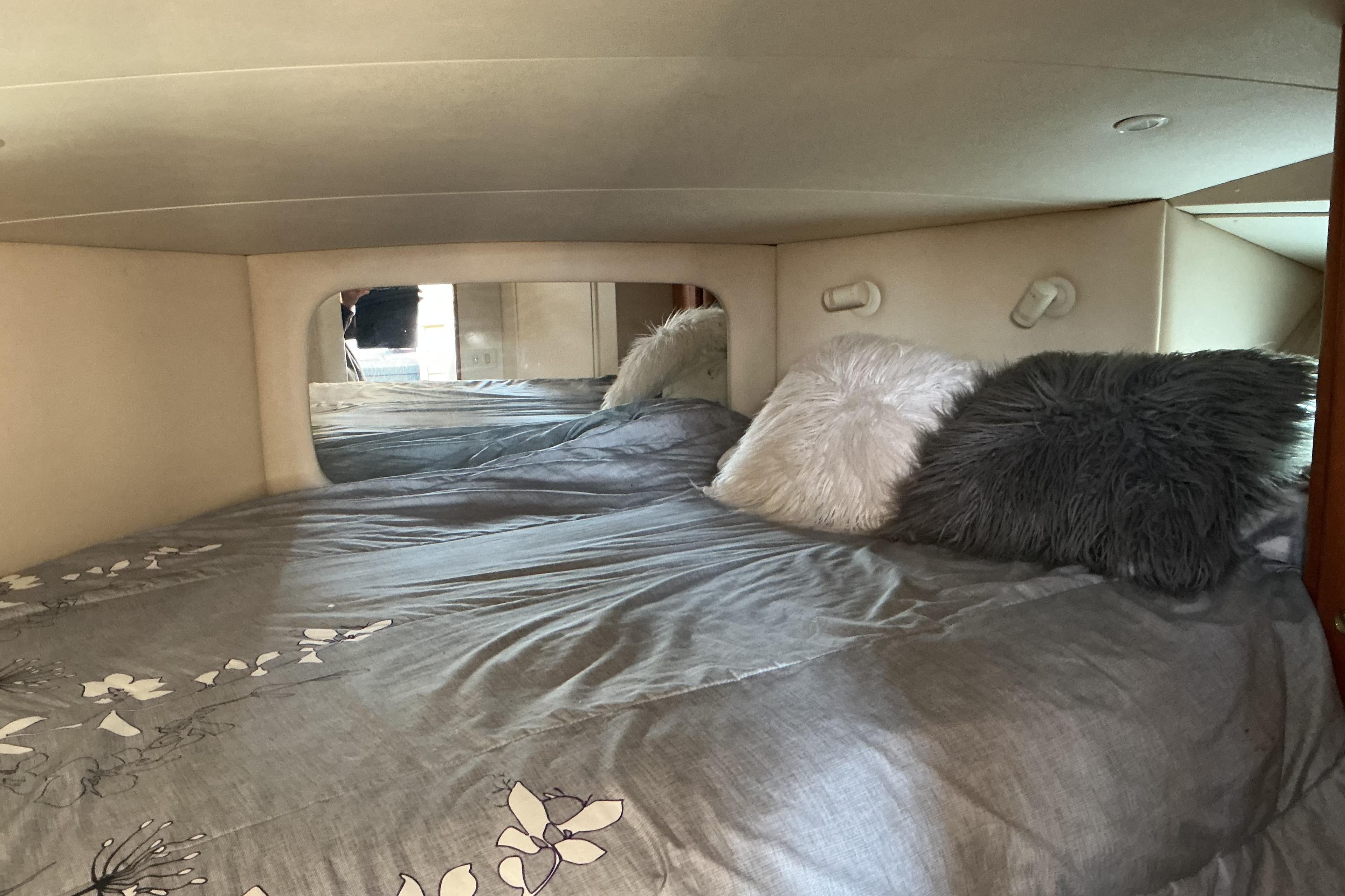 Cozy bedroom in 1999 Silverton 422 Motor Yacht with plush pillows and floral bedding.