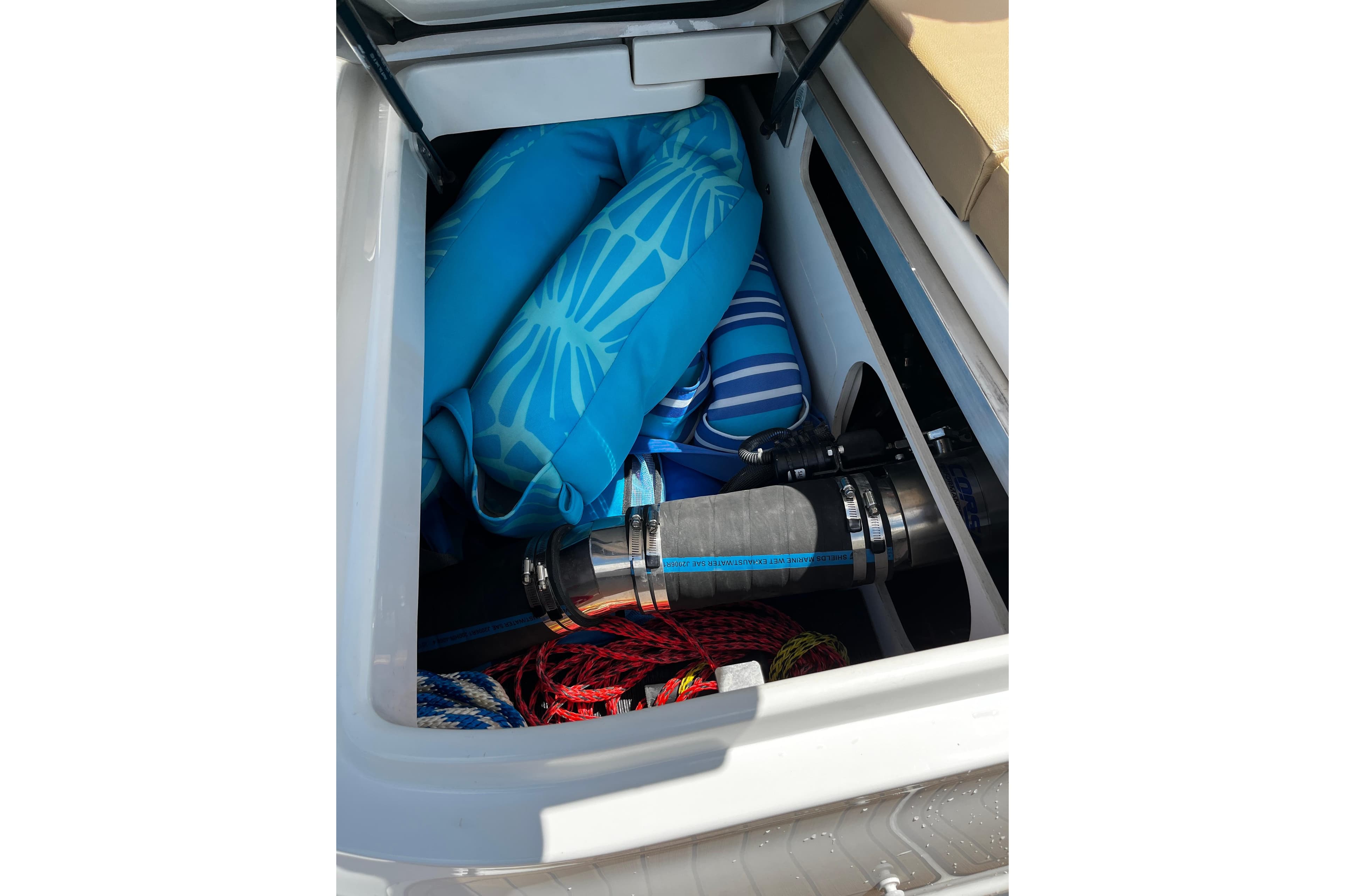 Storage compartment of 2019 Sea Ray SDX 270 boat with blue inflatables and equipment.