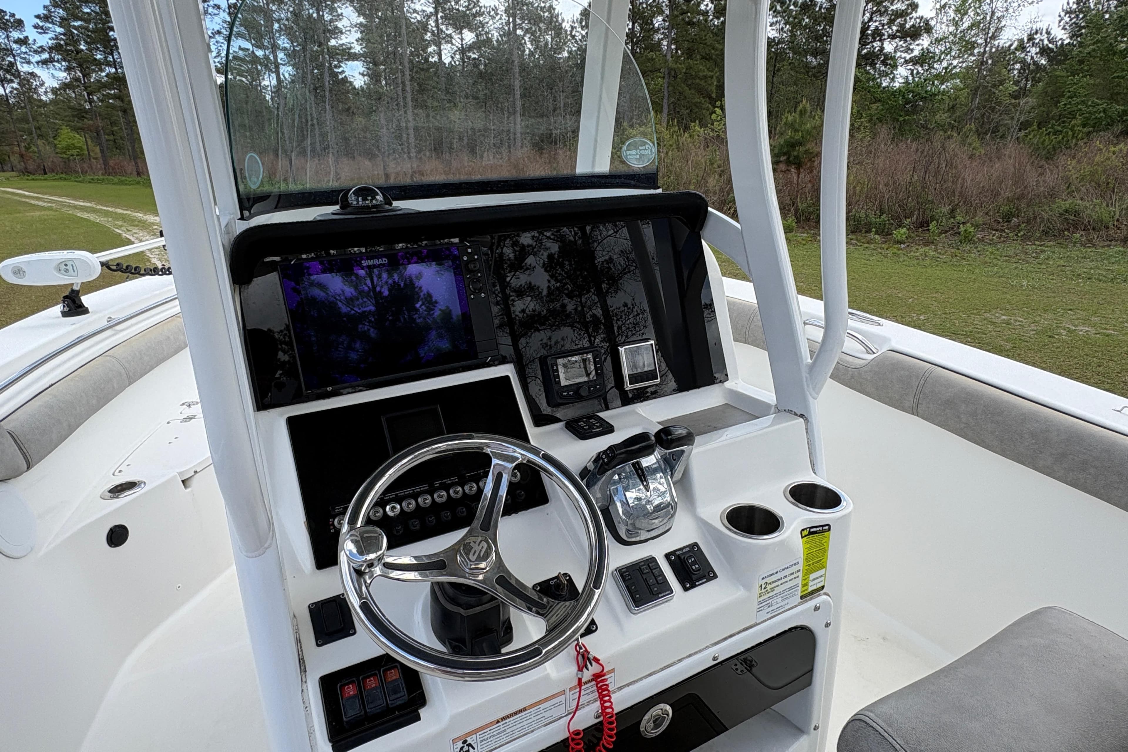 2021 Sea Pro 259 DLX boat dashboard with steering wheel and navigation controls.