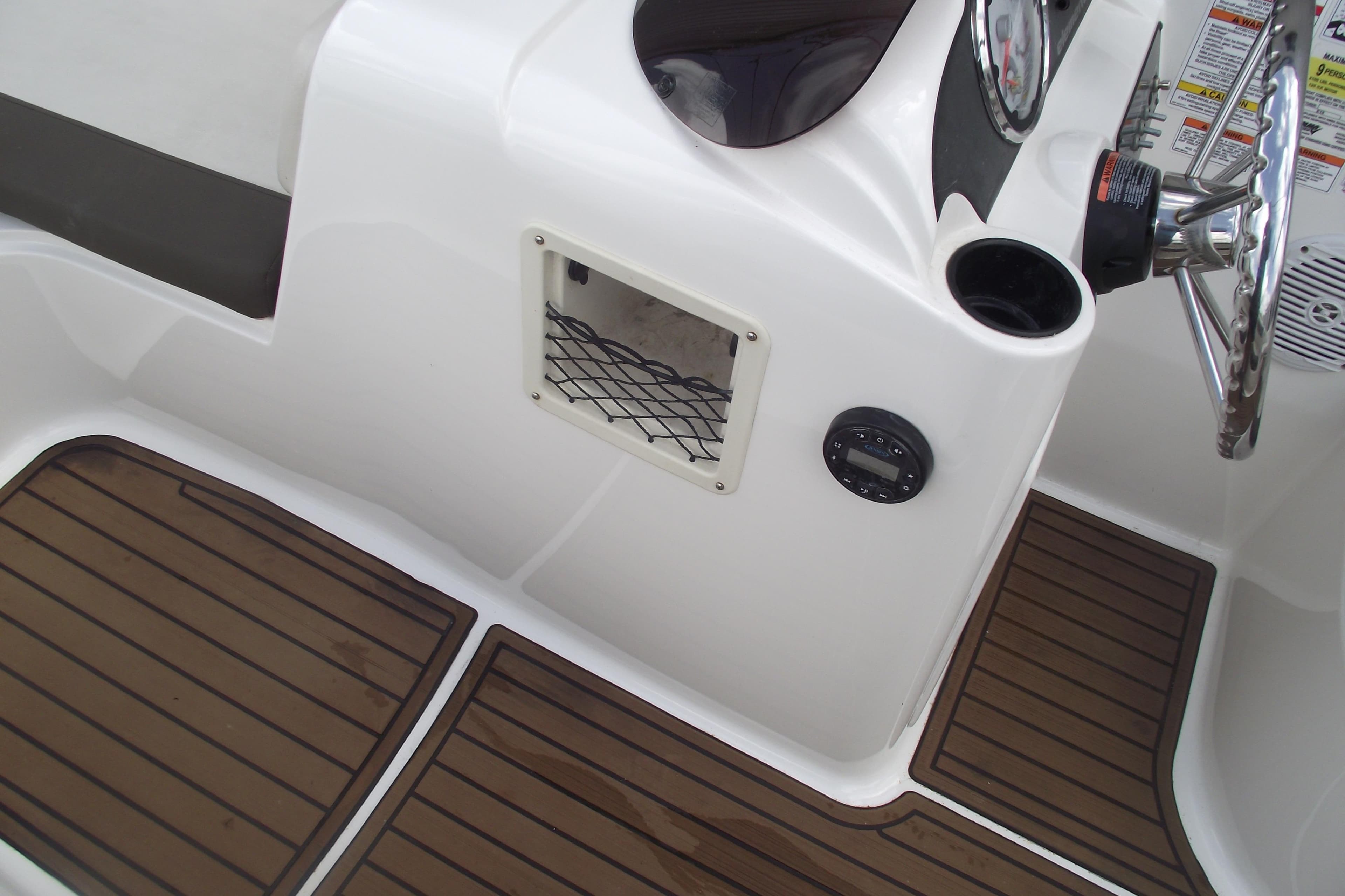 2021 Bayliner Element E18 boat interior with wood-style flooring and steering console.