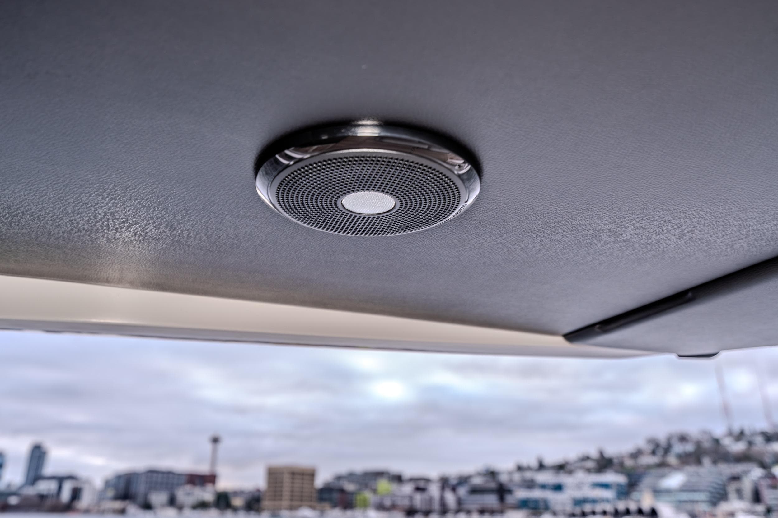 Ceiling speaker inside 2026 Absolute 48 Coupe yacht, with cityscape in the background.