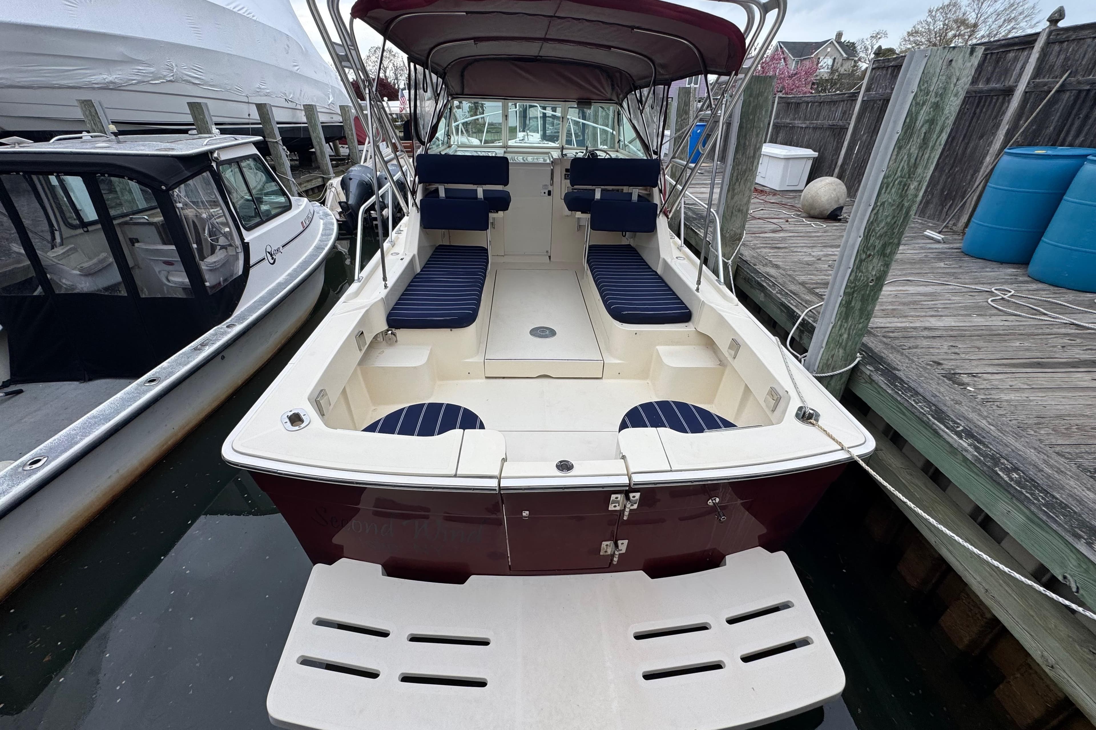 2001 Mainship Pilot 30 boat docked, featuring spacious seating and canopy.