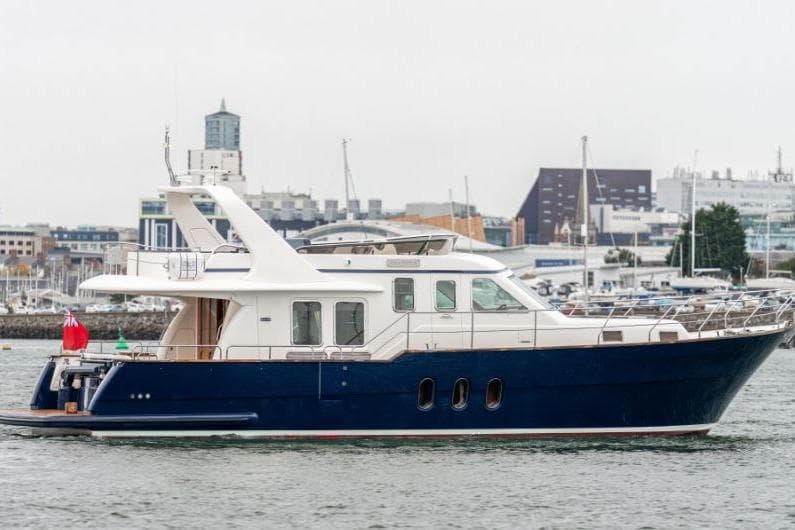 2007 Aquastar 57 yacht with blue hull, docked in a marina setting.
