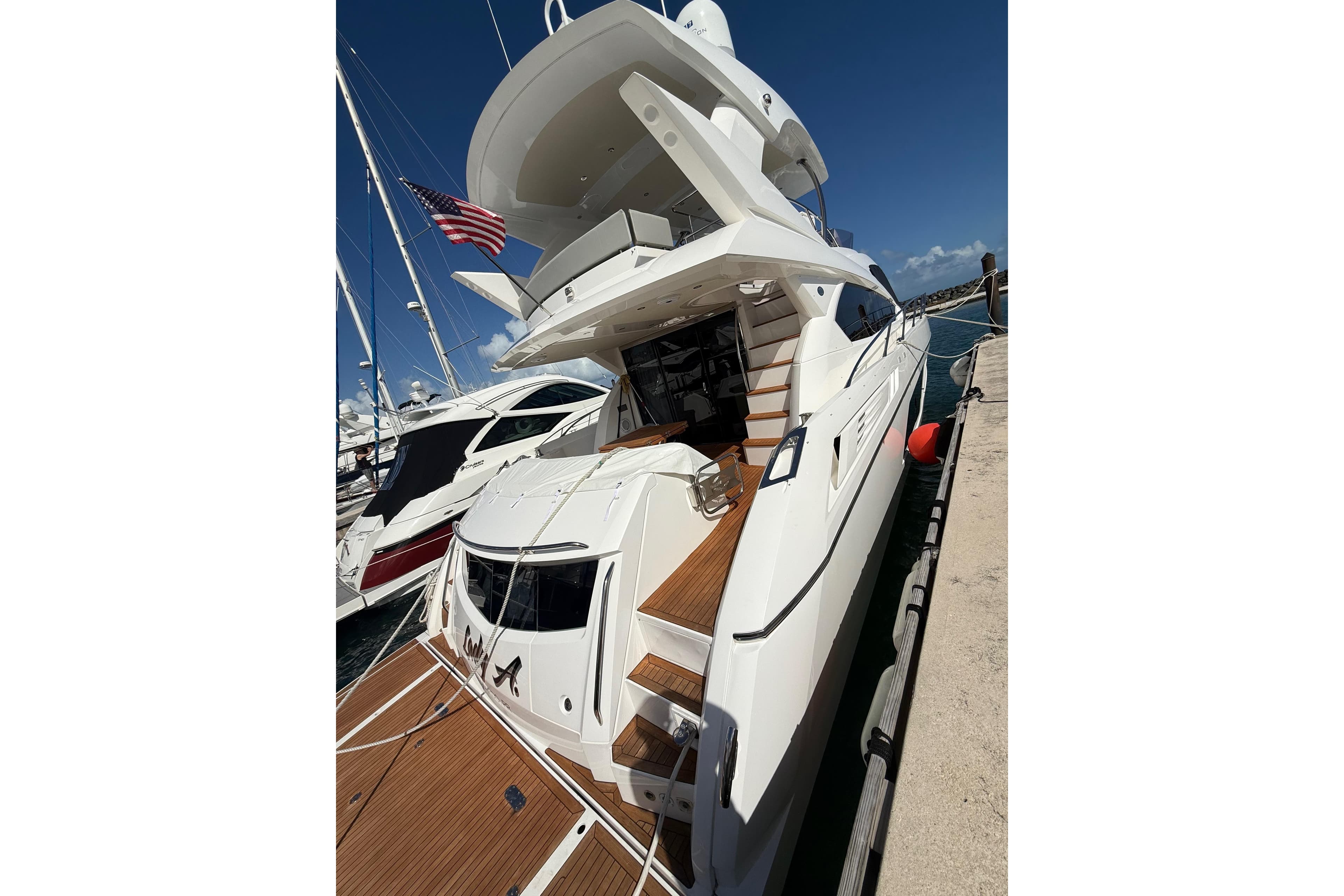 2017 Sunseeker Manhattan 65 yacht docked, featuring sleek design and American flag.