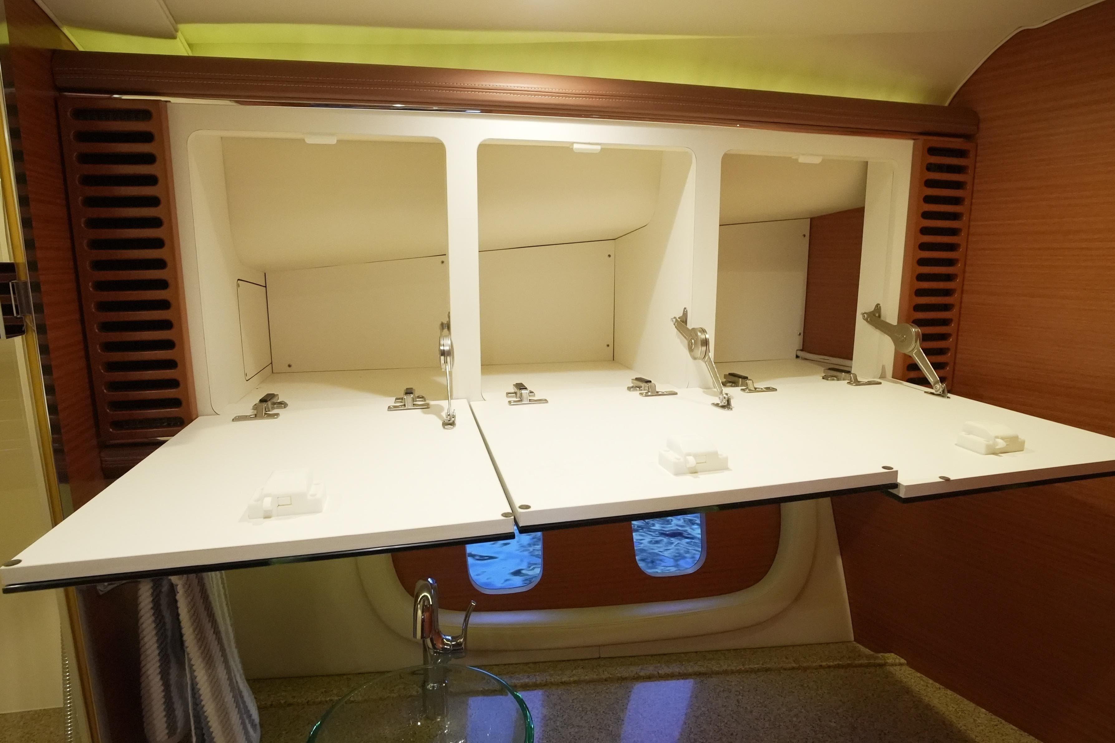 Interior storage cabinets on a 2013 Zeelander Z44 yacht, featuring open white compartments.