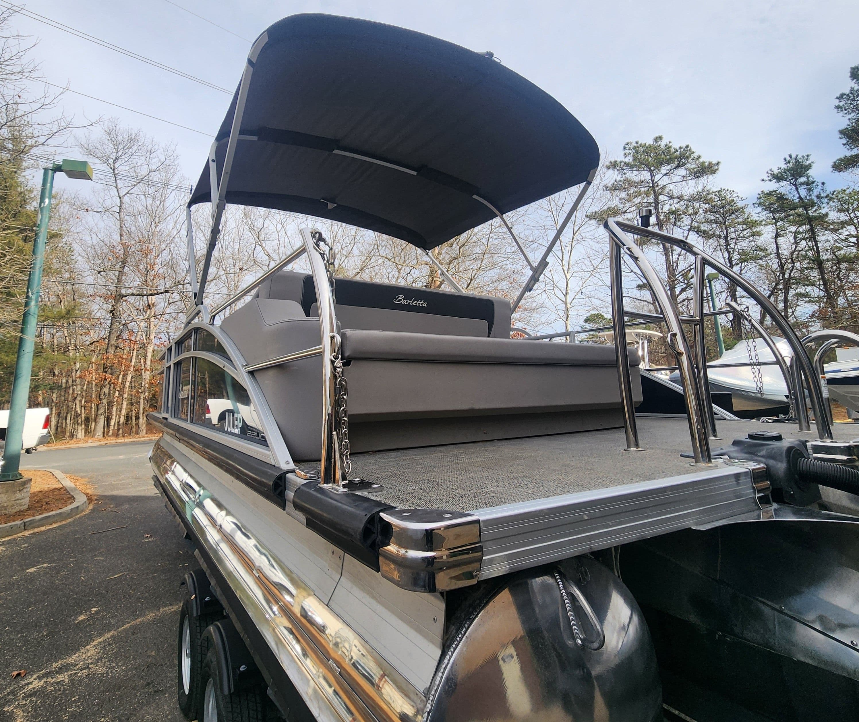 2025 Barletta ARIA 22UC pontoon boat with canopy, parked outdoors.
