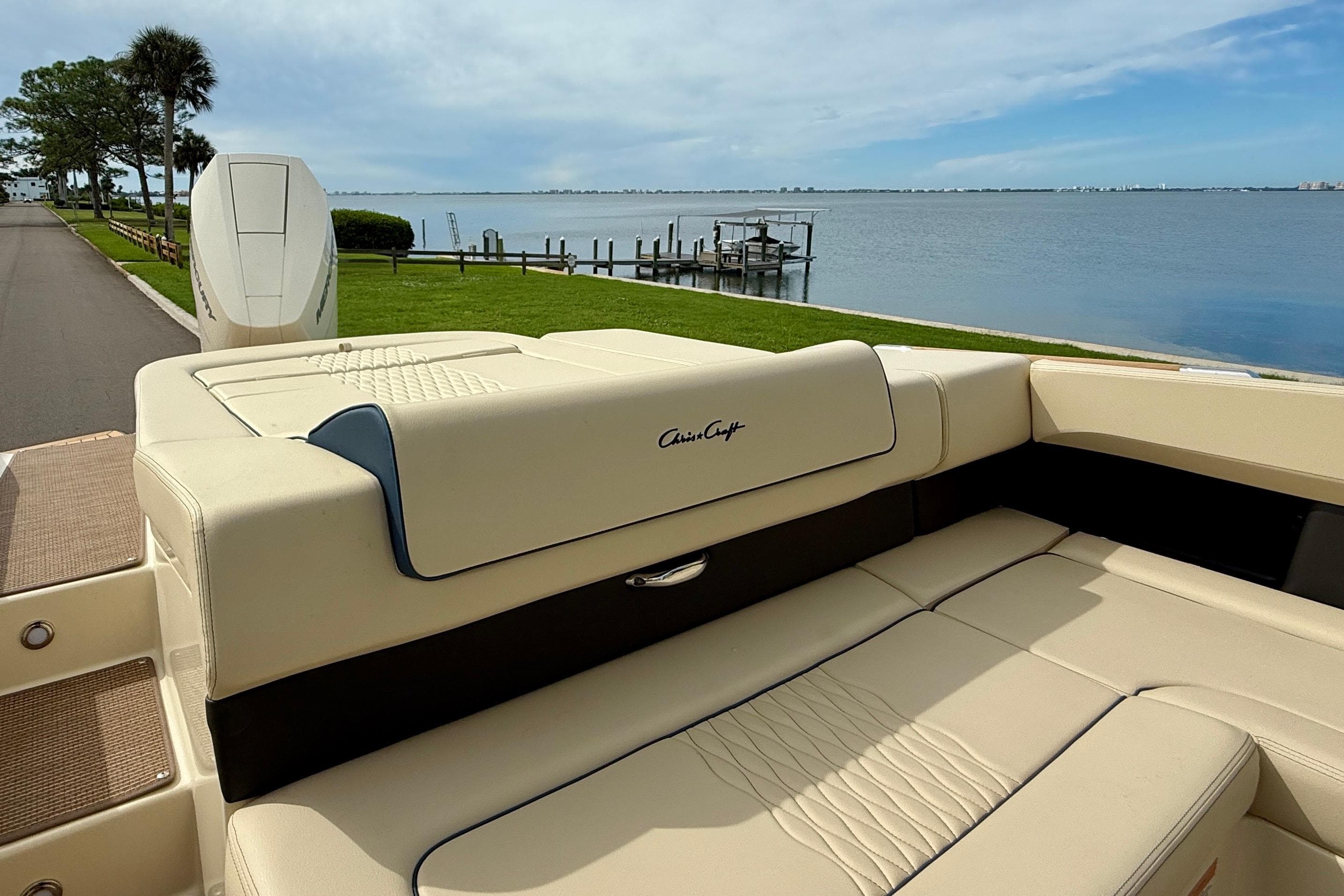 2026 Chris-Craft Sportster 28 boat with luxurious seating by a serene waterfront.