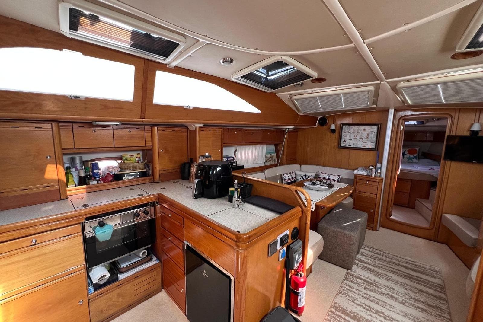 Luxurious interior of a 2007 Bavaria 44 Vision yacht with modern kitchen and dining area.