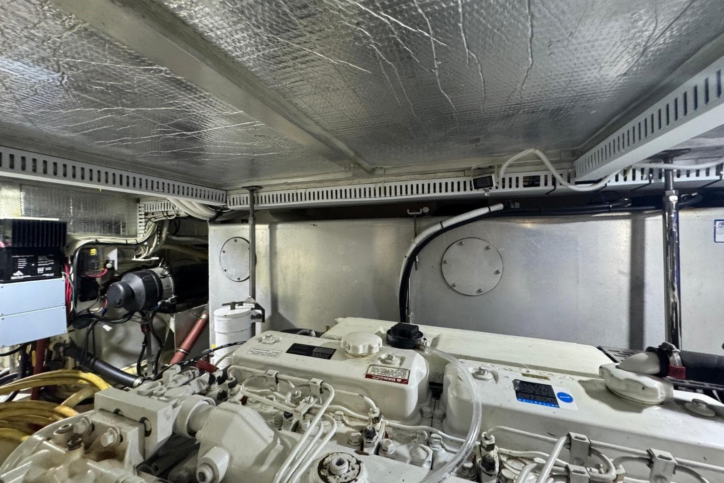 Engine room of 2004 Carver 564 Cockpit Motor Yacht, showcasing mechanical components and wiring.