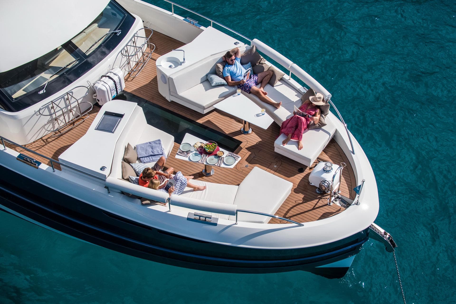 2025 Van der Valk BeachClub 660 Flybridge yacht with people relaxing on deck.