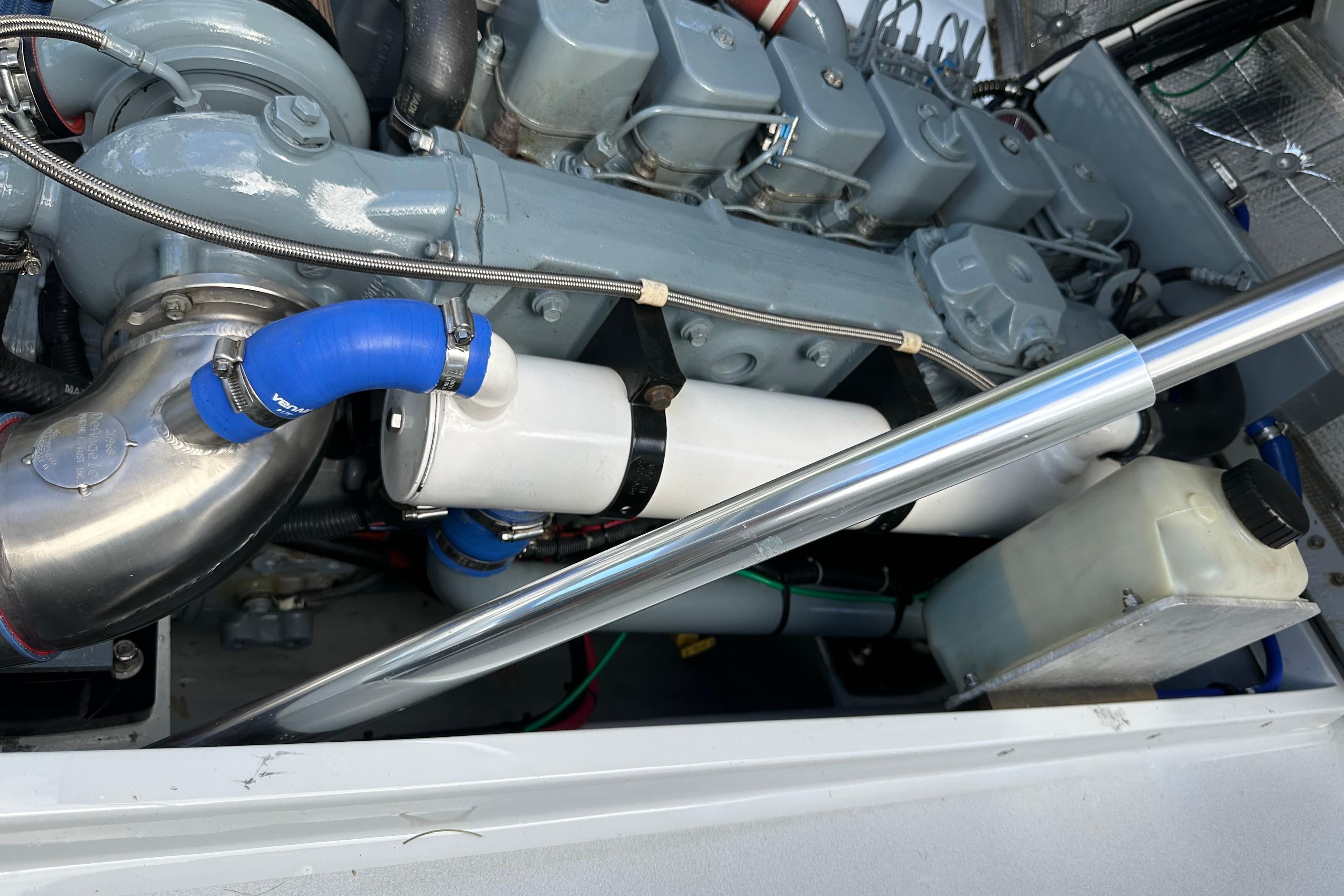 2004 SeaVee Center Console engine with blue hoses and metal components.